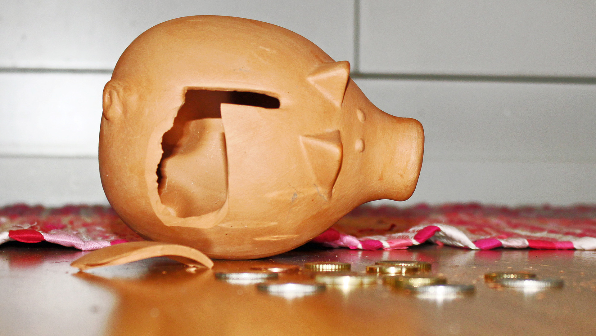 En krossad spargris och småmynt som ligger på ett bord.