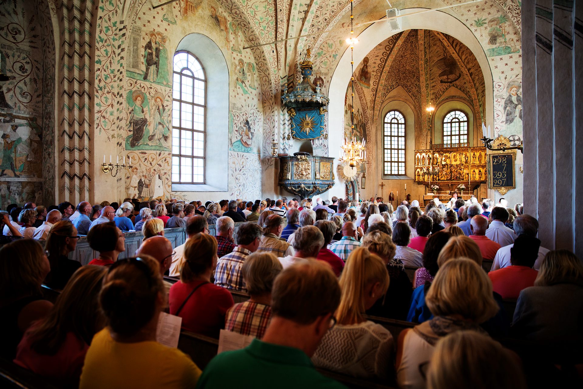 Gudstjänstbesökare i en fullsatt kyrka.