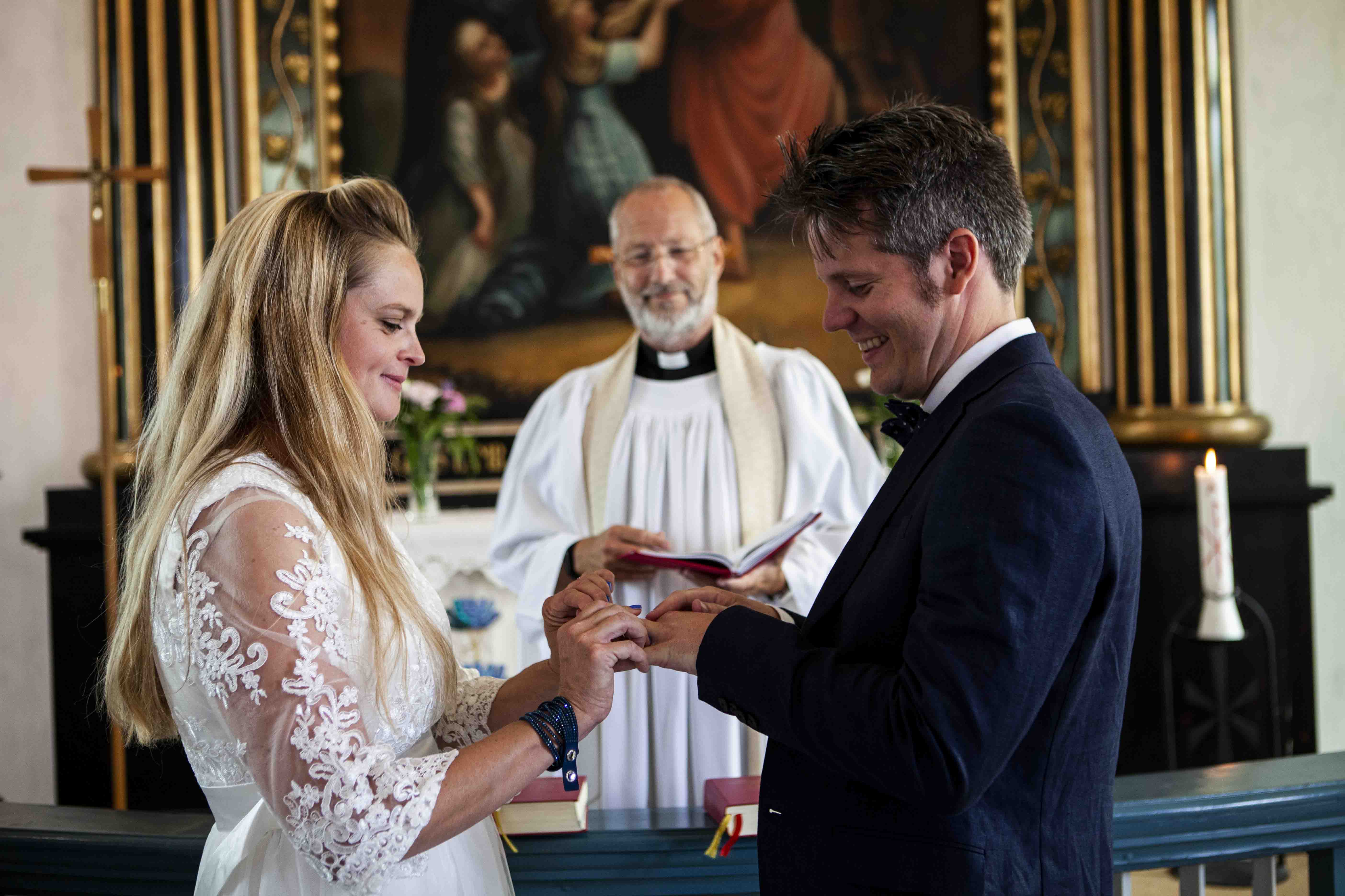Brudpar i kyrka tillsammans med präst