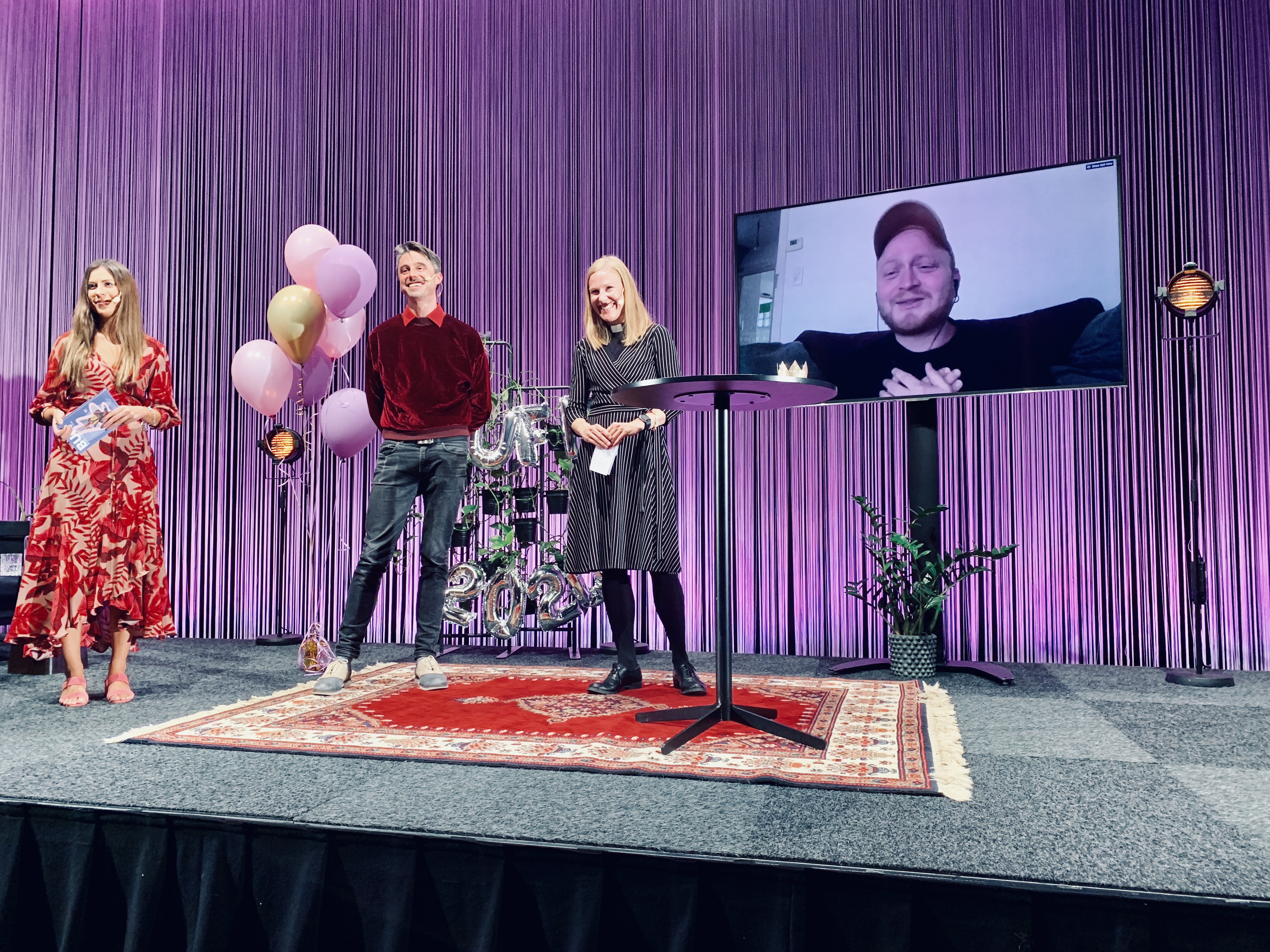 Utdelning på scen av Svenska kyrkans ungdomsfilmspris. På en stor skärm syns vinnaren, Laurent Micheli.