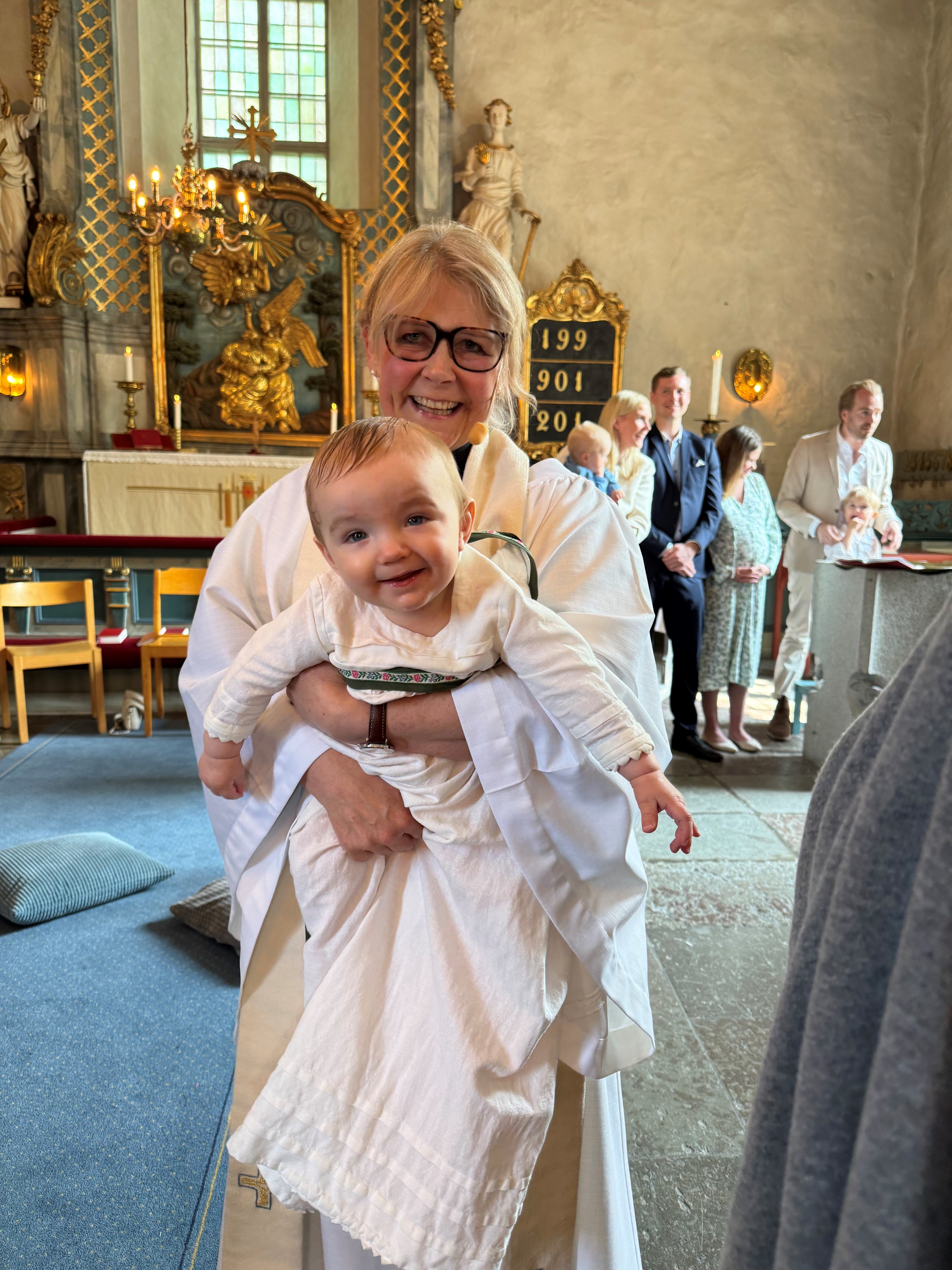 Kyrkoherde Sara J Grip tillsammans med dopbarnet.