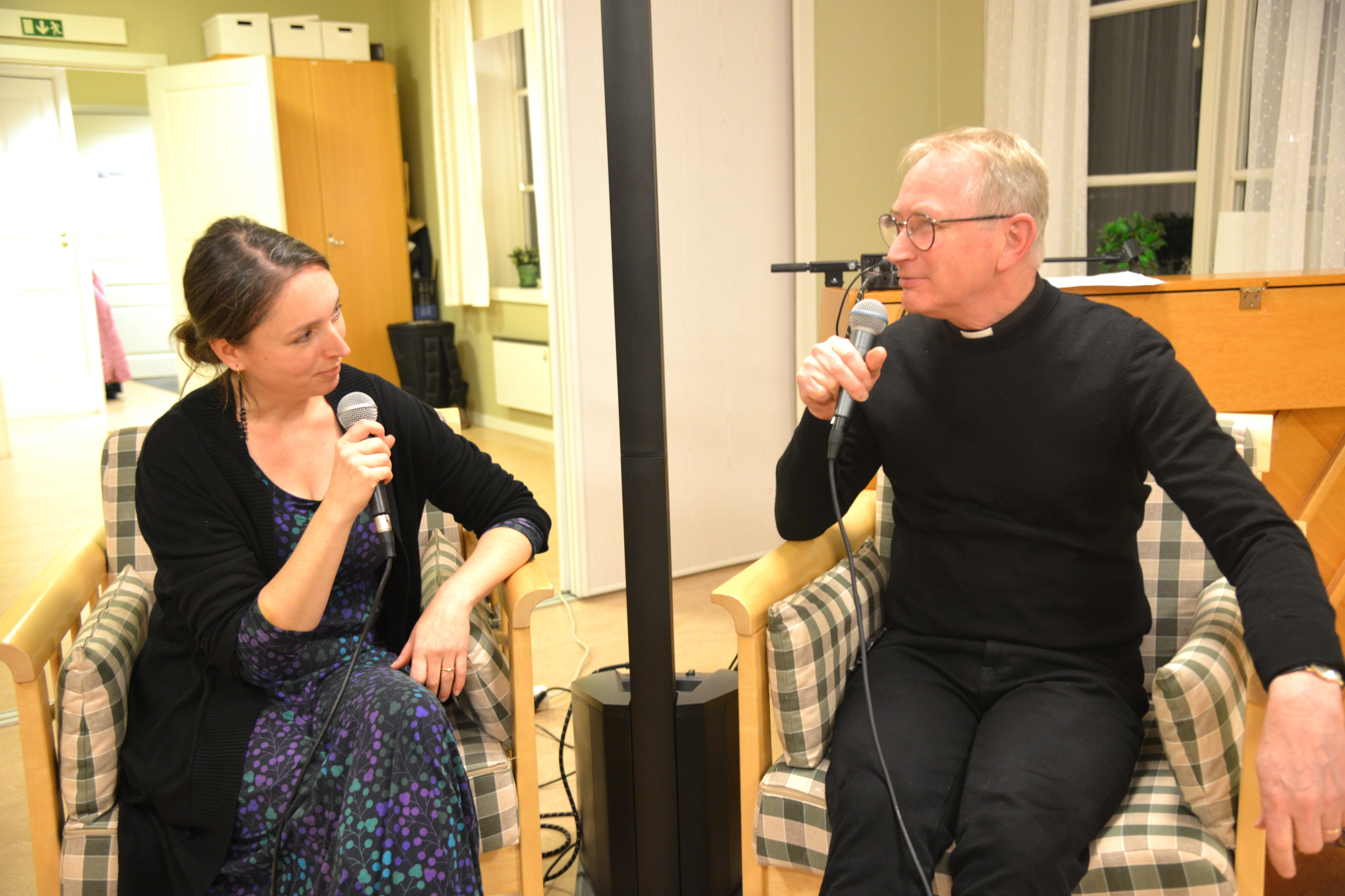 Två personer sitter i varsin fåtölj och samtalar