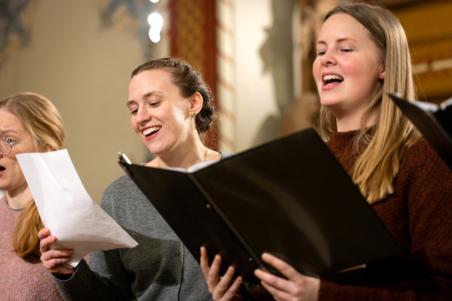 Tre körsångare sjunger.