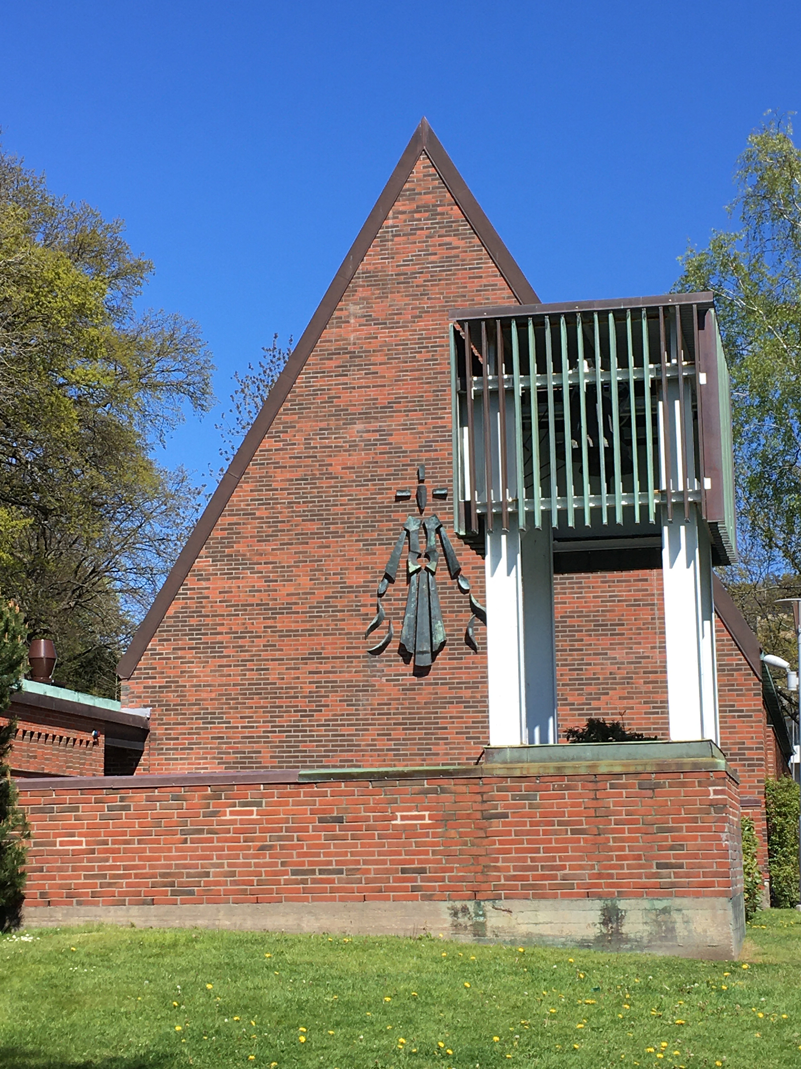Skårs kyrkas tegelfasad en vårdag.