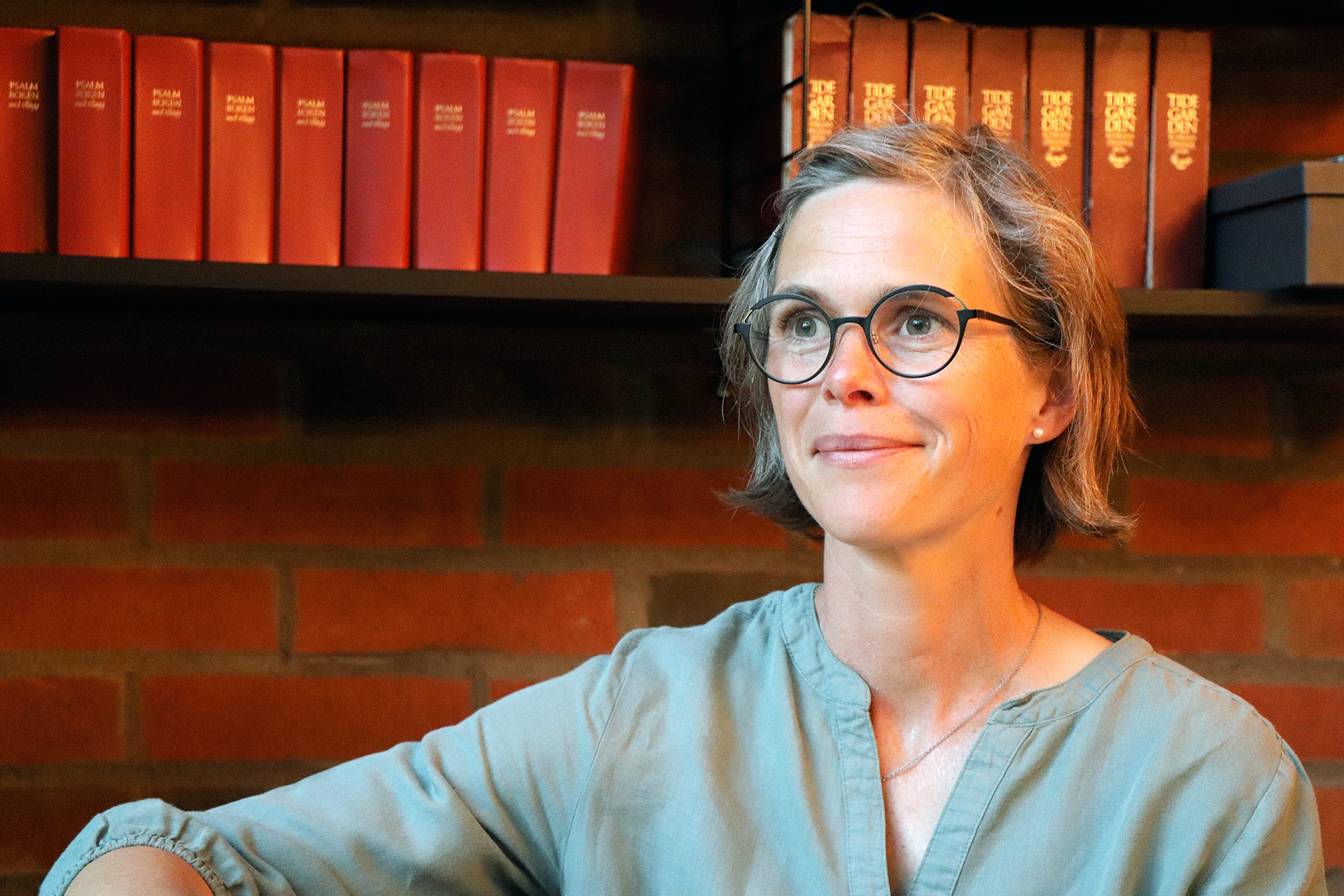 En person med glasögon tittar ut mot vänster. 