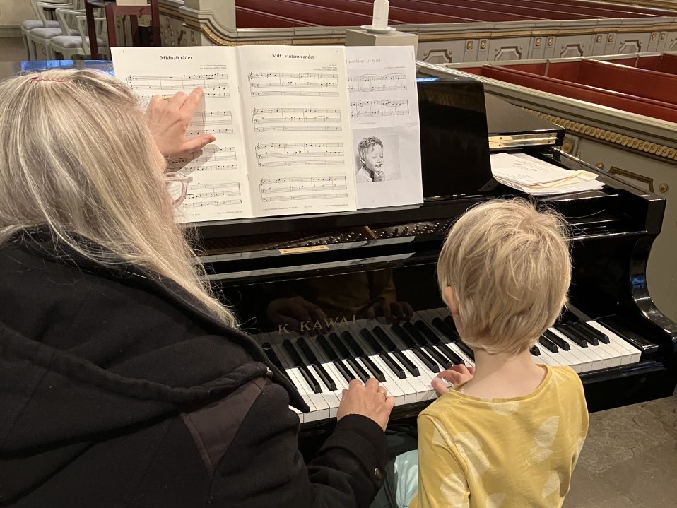Pianolärare undervisar elev vid flygel