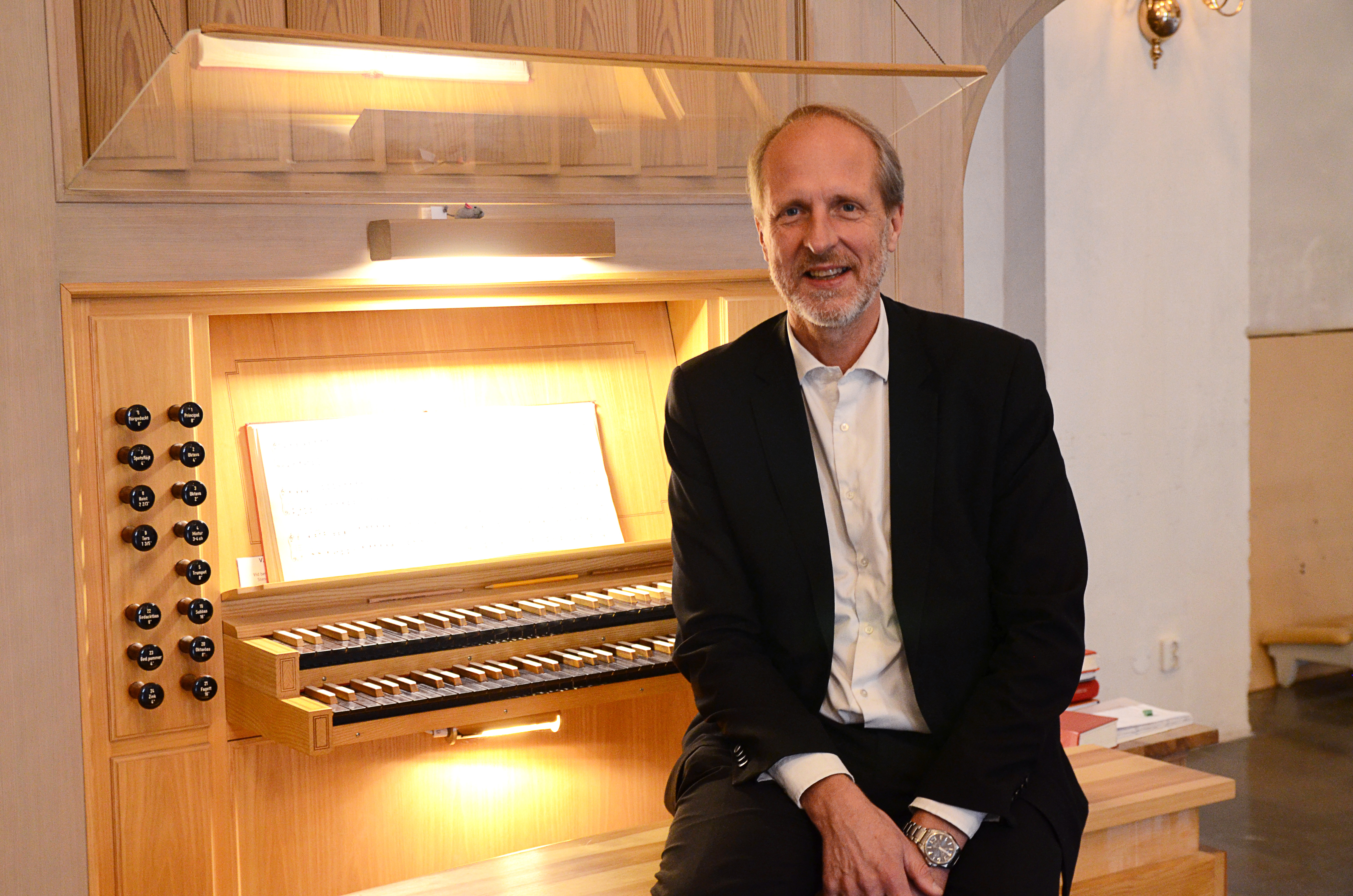Domkyrkoorganist Sten-Inge Petersson sitter vid orgeln i Växjö domkyrka och tittar in i kameran..