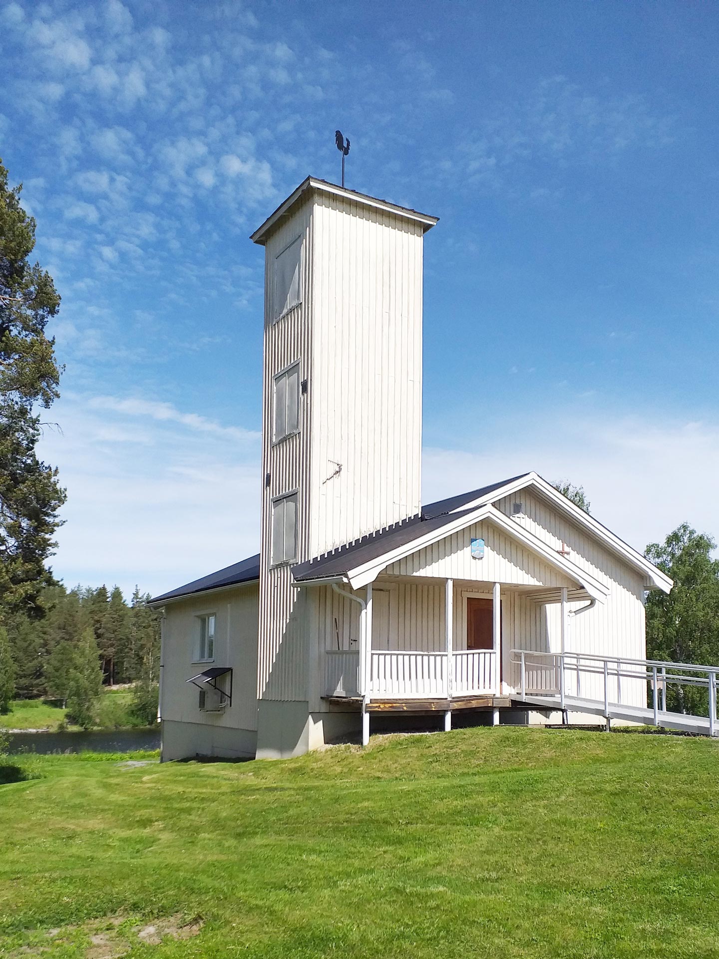 Valvikens kyrksal. Exteriörbild i sommargrönska.