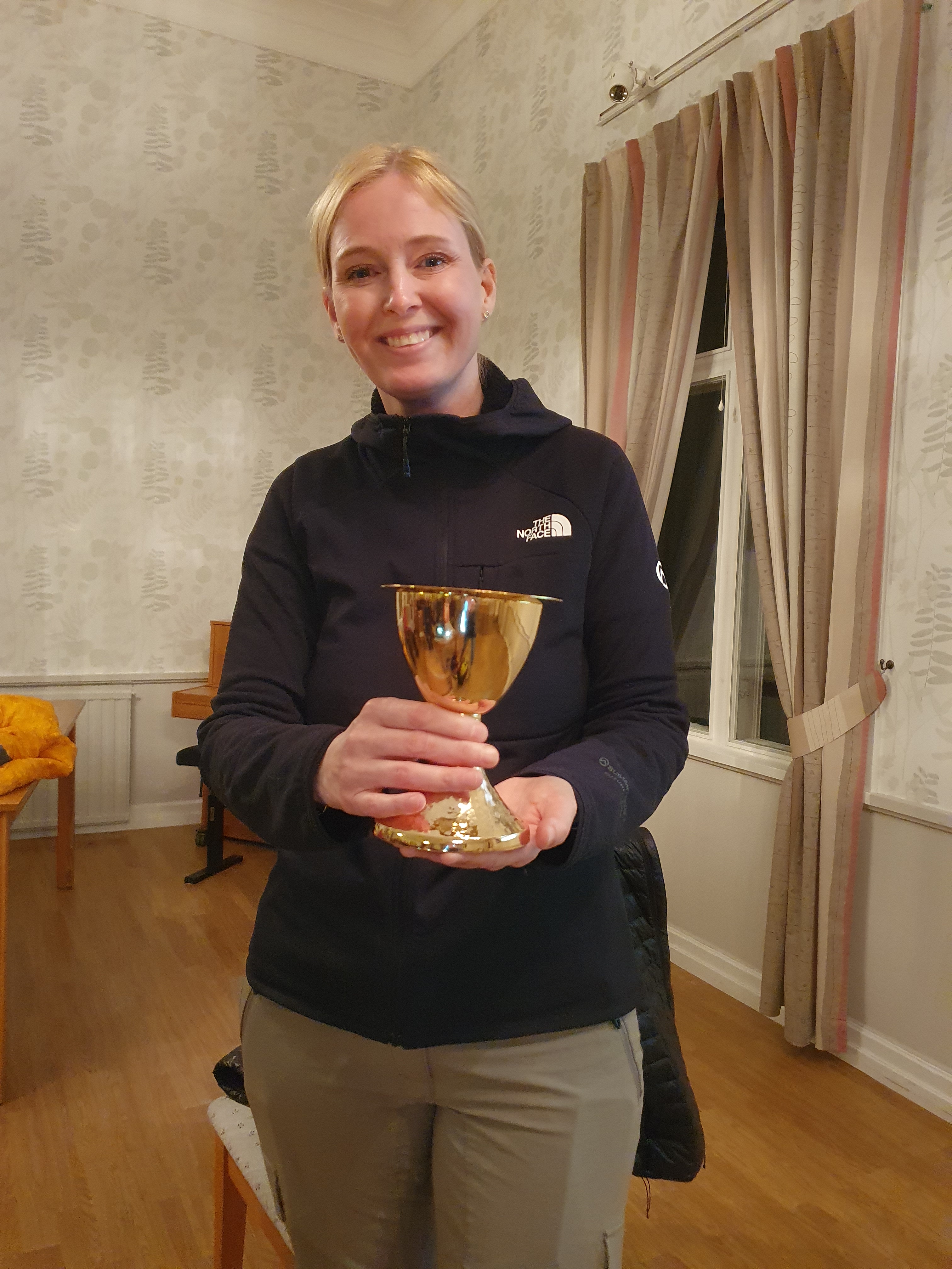 En kvinna som står och håller i en bägare.