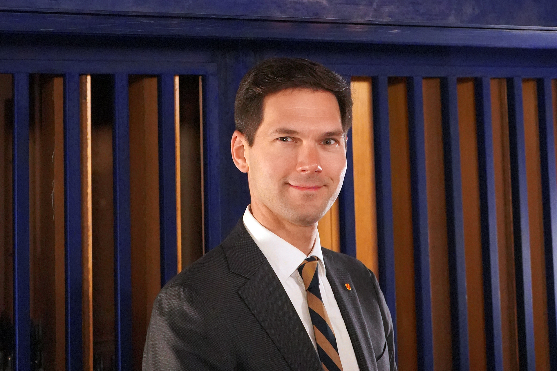 Robert bennesh i kostym och randig slips porträtterad framför Ruffattioreglens klart blå fasad på orgelläktaren i norra koret i Uppsala domkyrka.