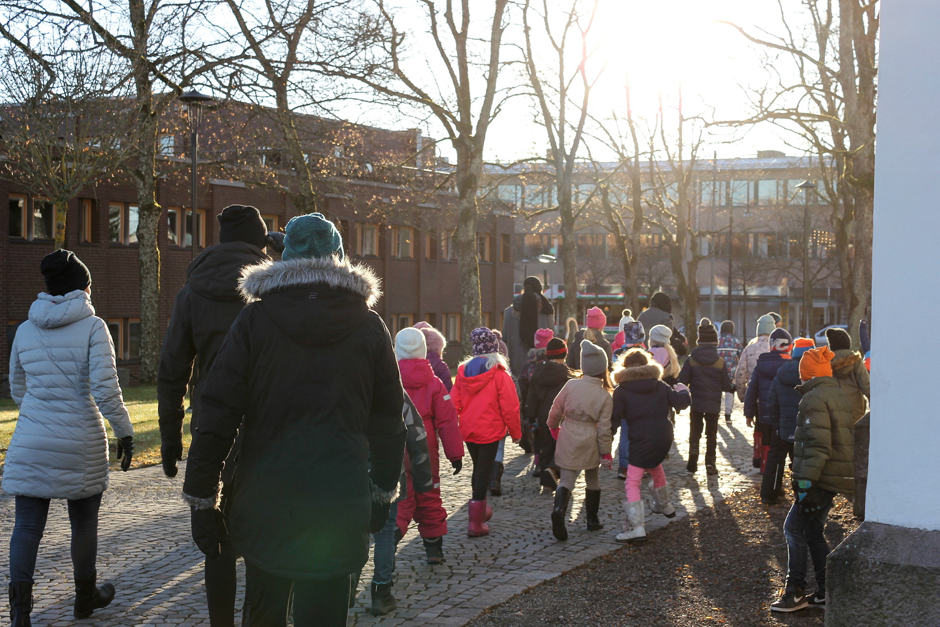 En grupp elever och två vuxna går bortåt utomhus