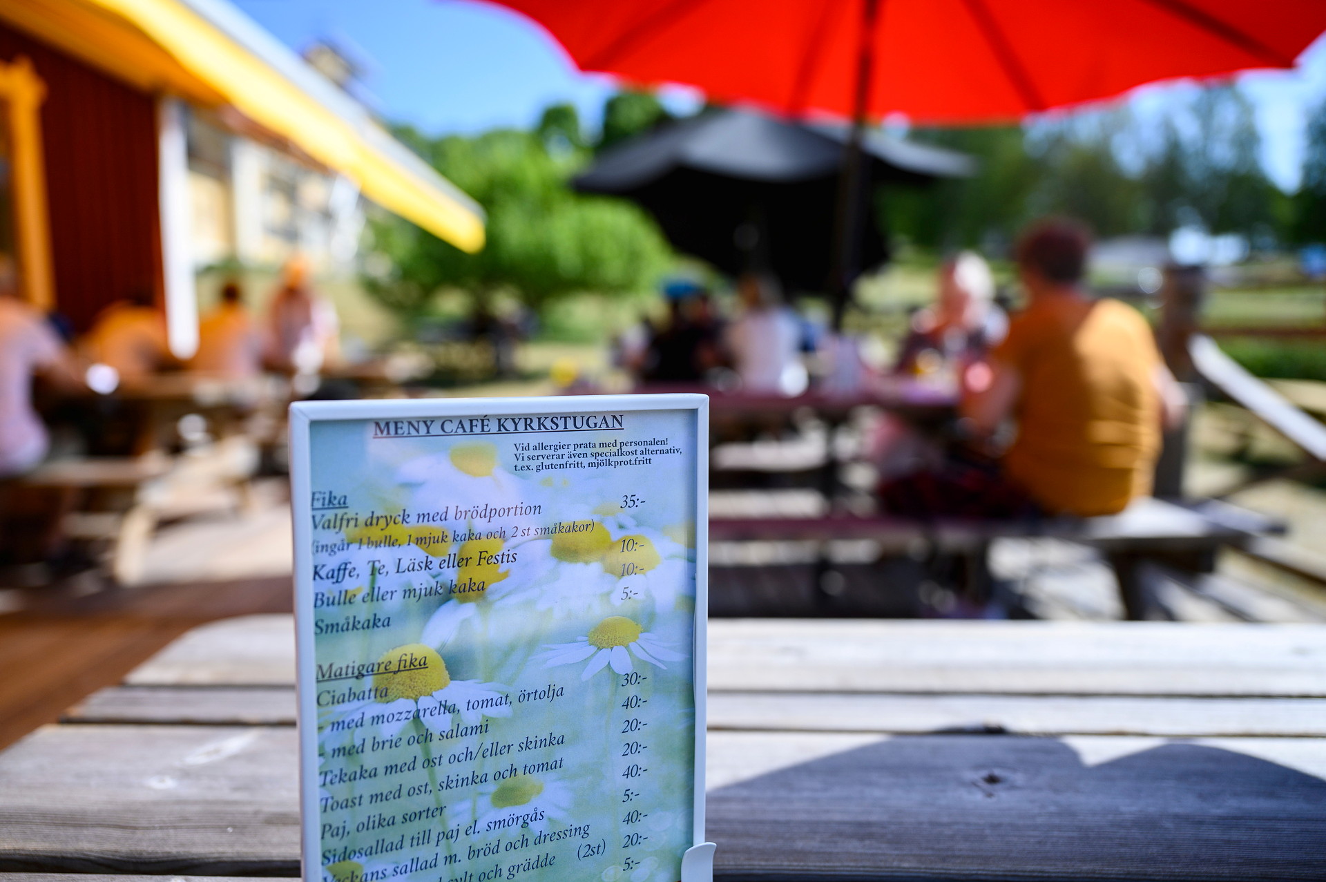 meny med cafémiljö utomhus i bakgrunden