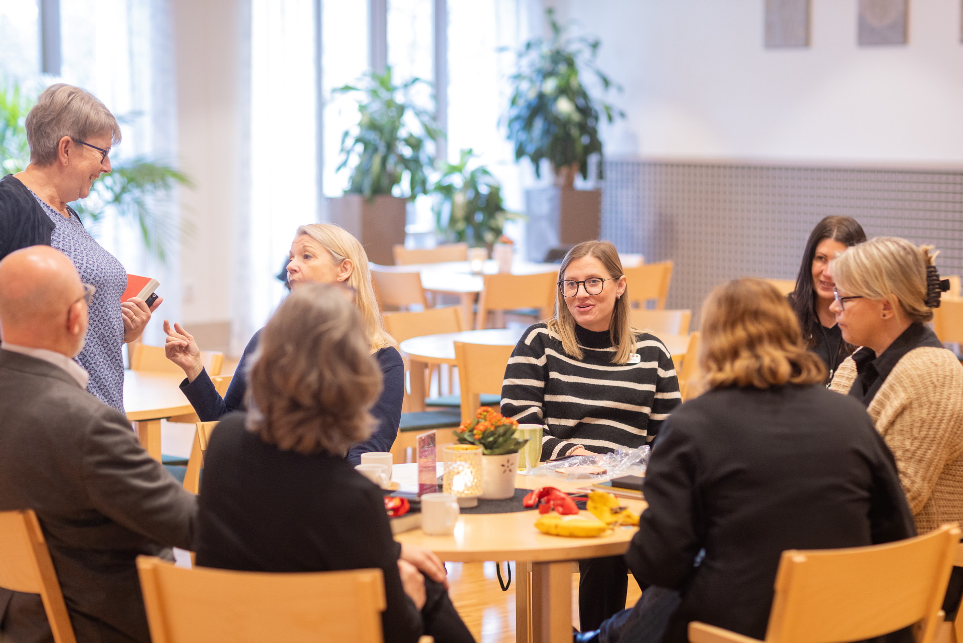 Några personer sitter runt ett bord med fika