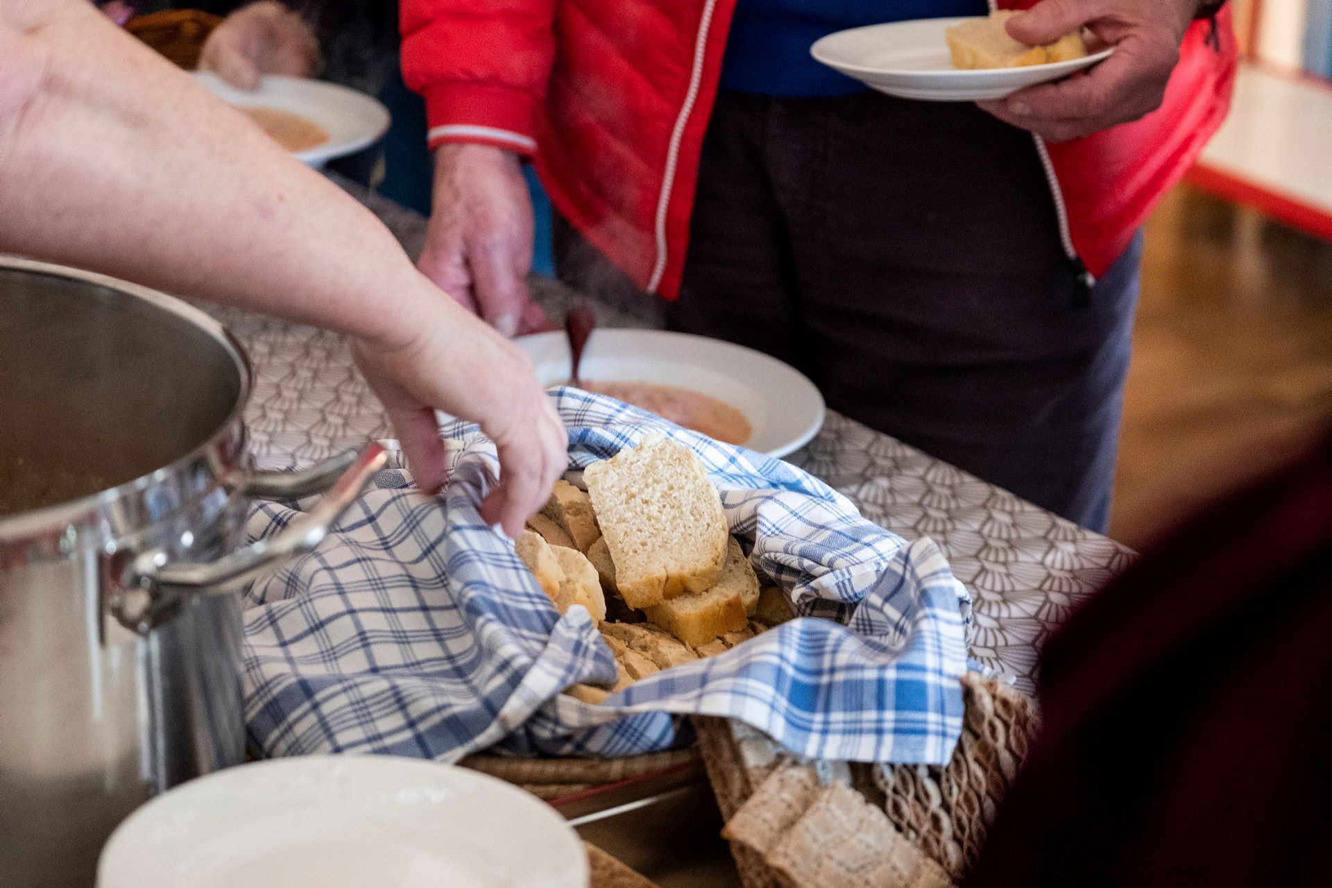 Någon tar en brödskiva ur den framställda korgen.