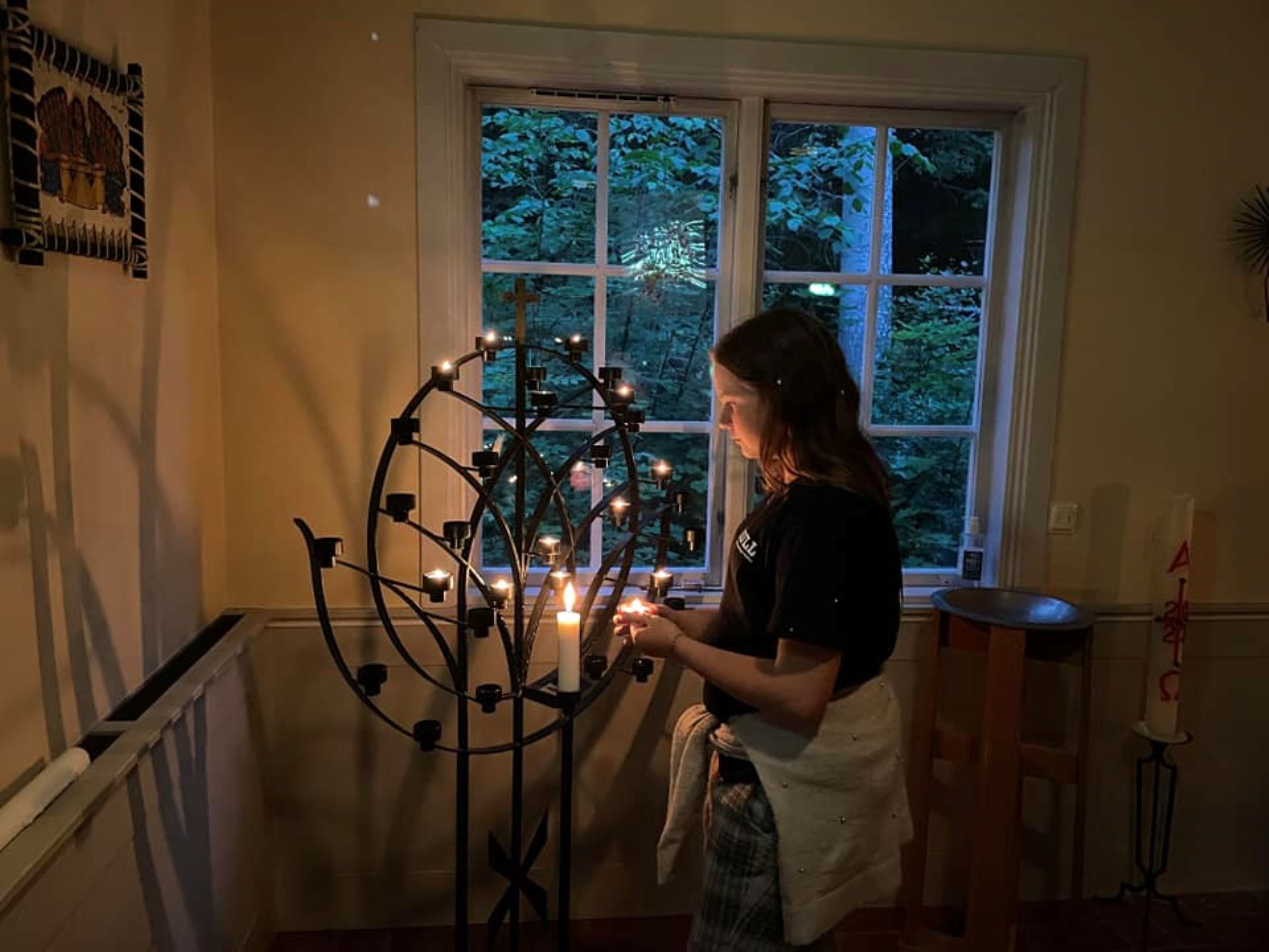 Ungdom vid ljusbärare tänder ett ljus