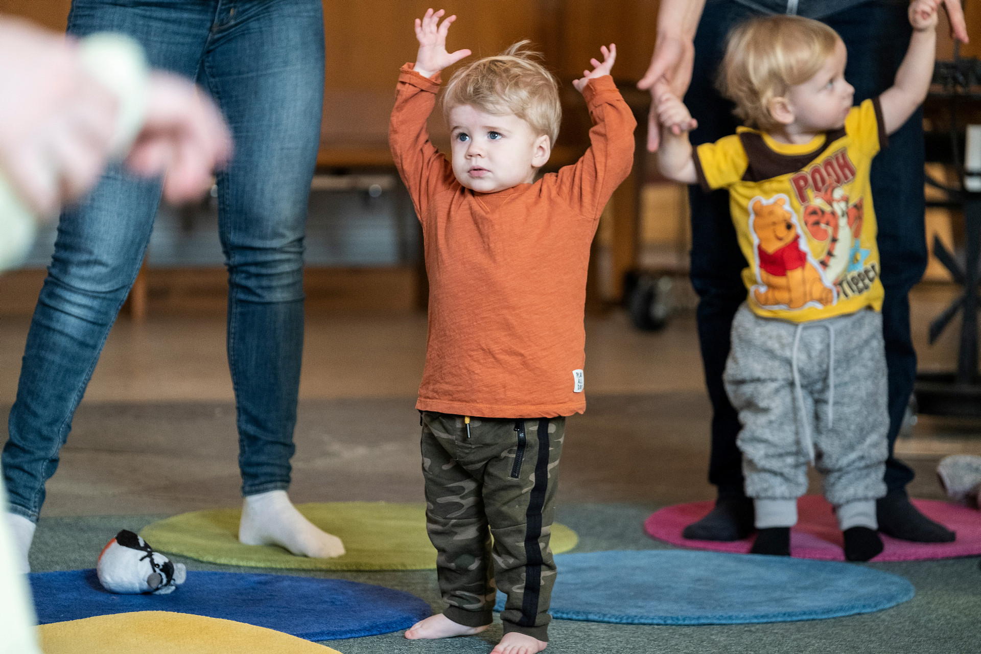 Ett barn som sträcker upp händerna över huvudet. 