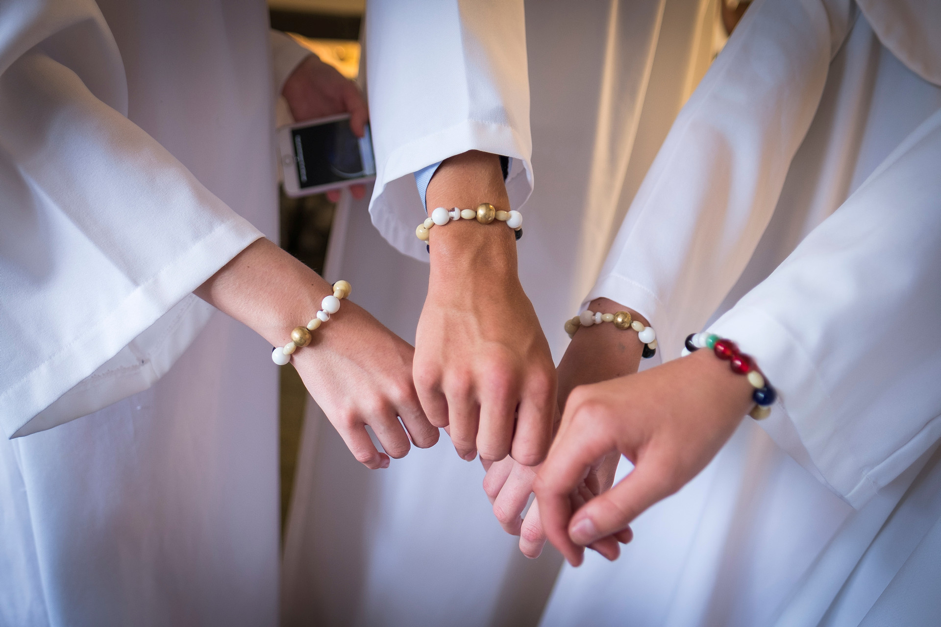 händer med pärlband