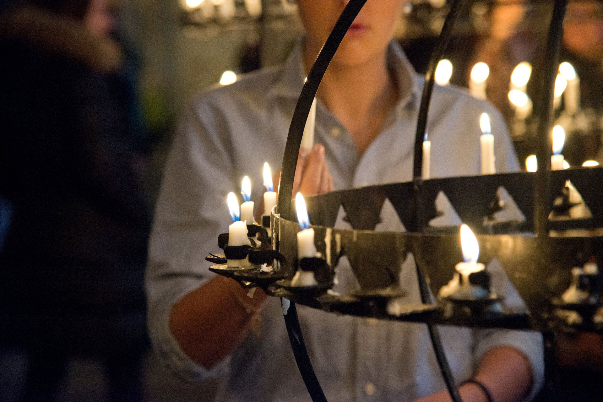 Tjej tänder ljus i ljusbäraren.