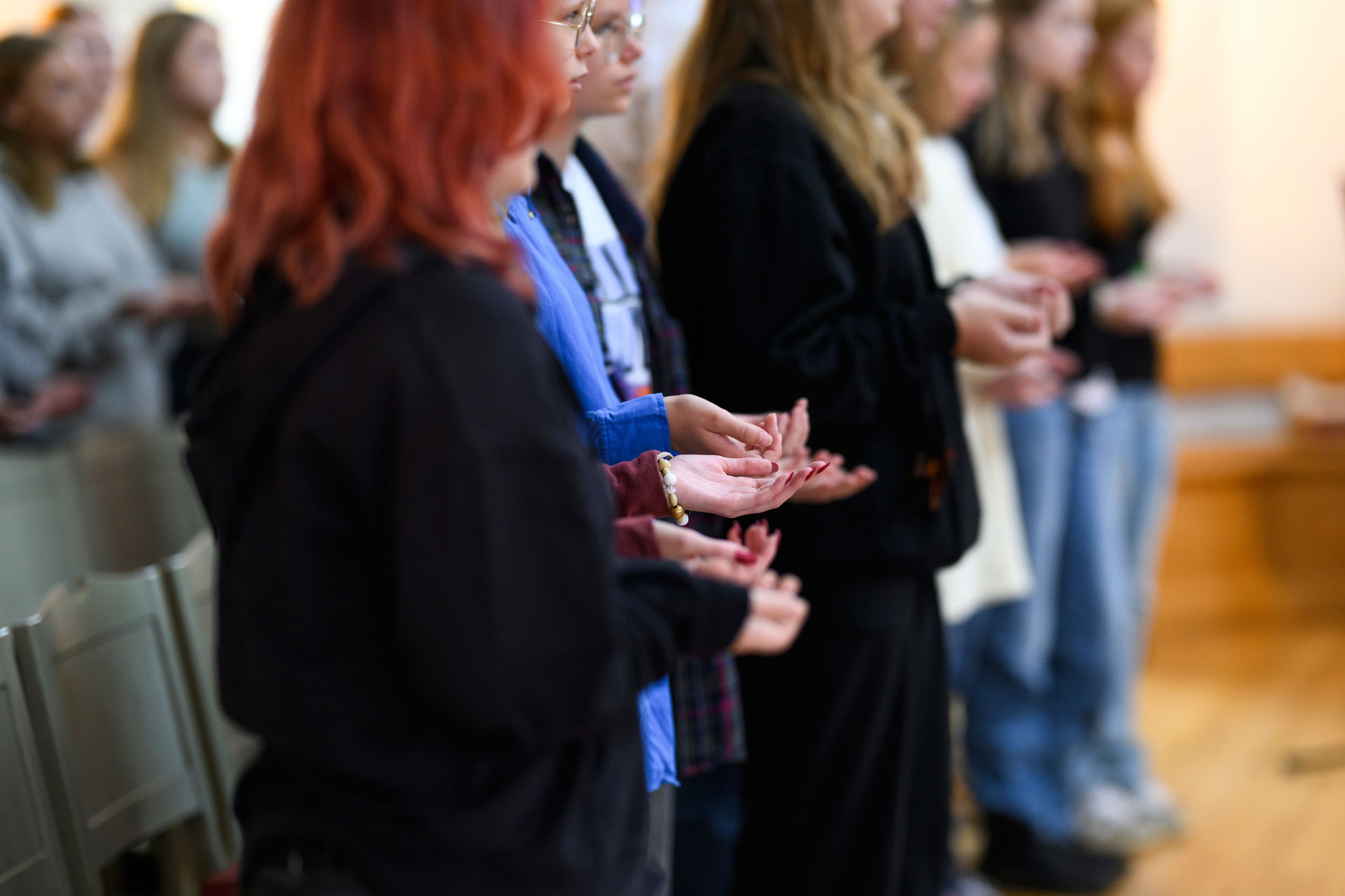 Människor på rad med händerna utsträckta för att ta emot välsignelsen.