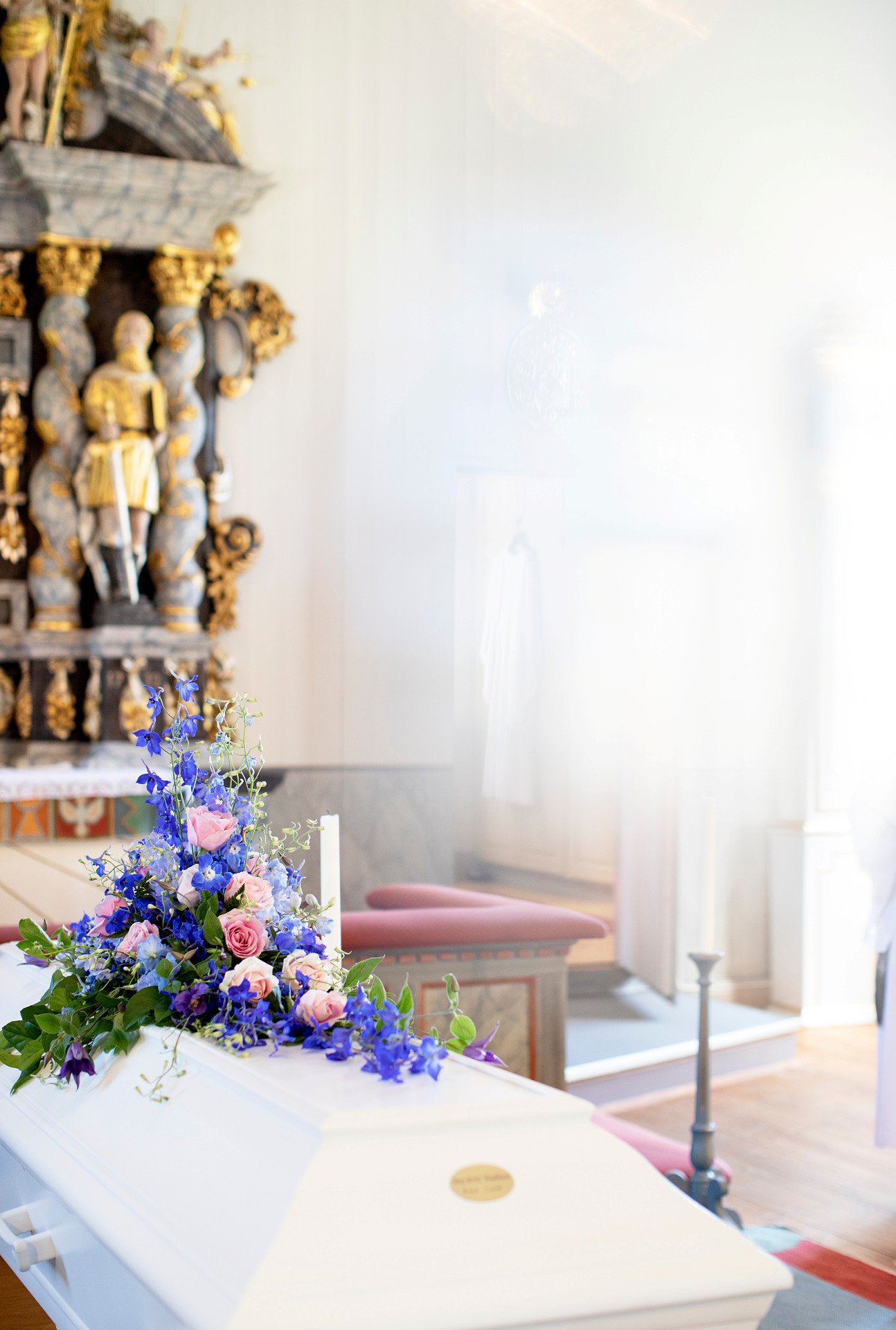 Vit kista med lila blommor på.