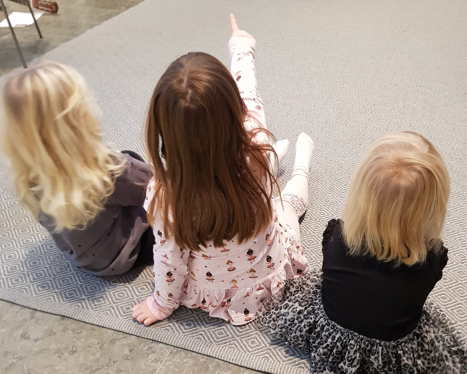 Barn som sitter i halv ring på golv