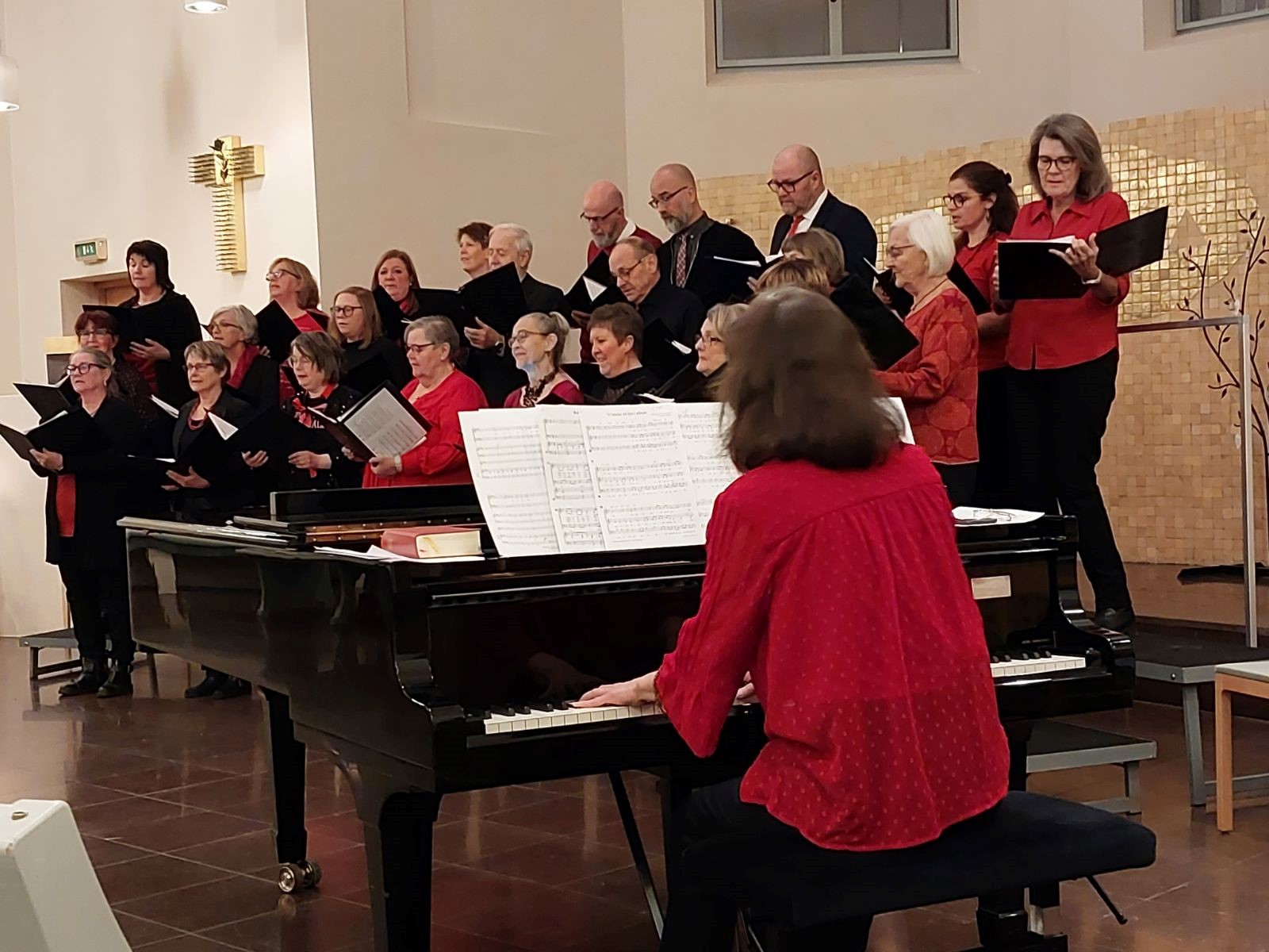 Norrala-Trönö kyrkokör, klädda i rött och svart sjunger i Trönö kyrka.