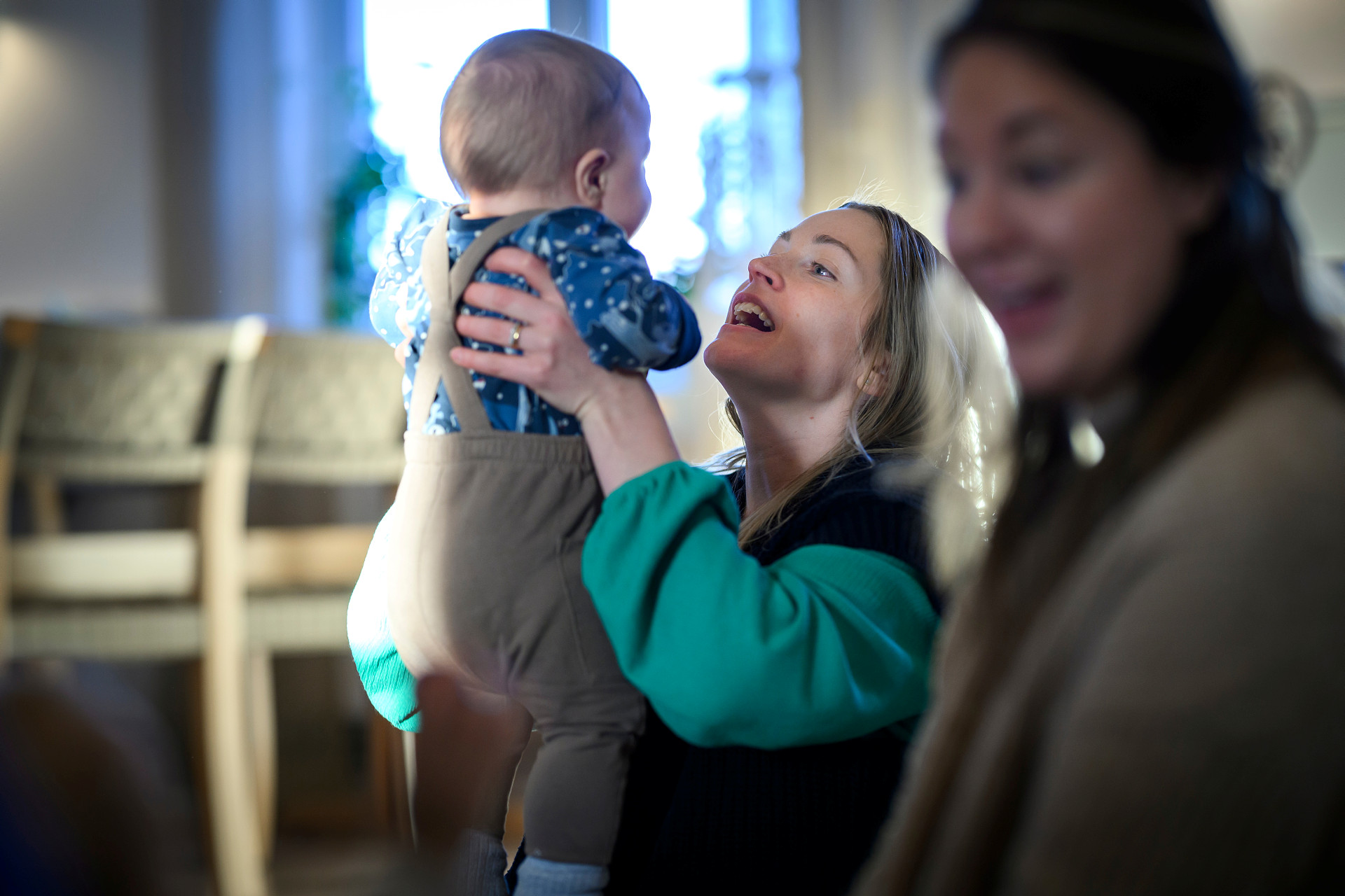 En kvinna håller upp ett litet barn.