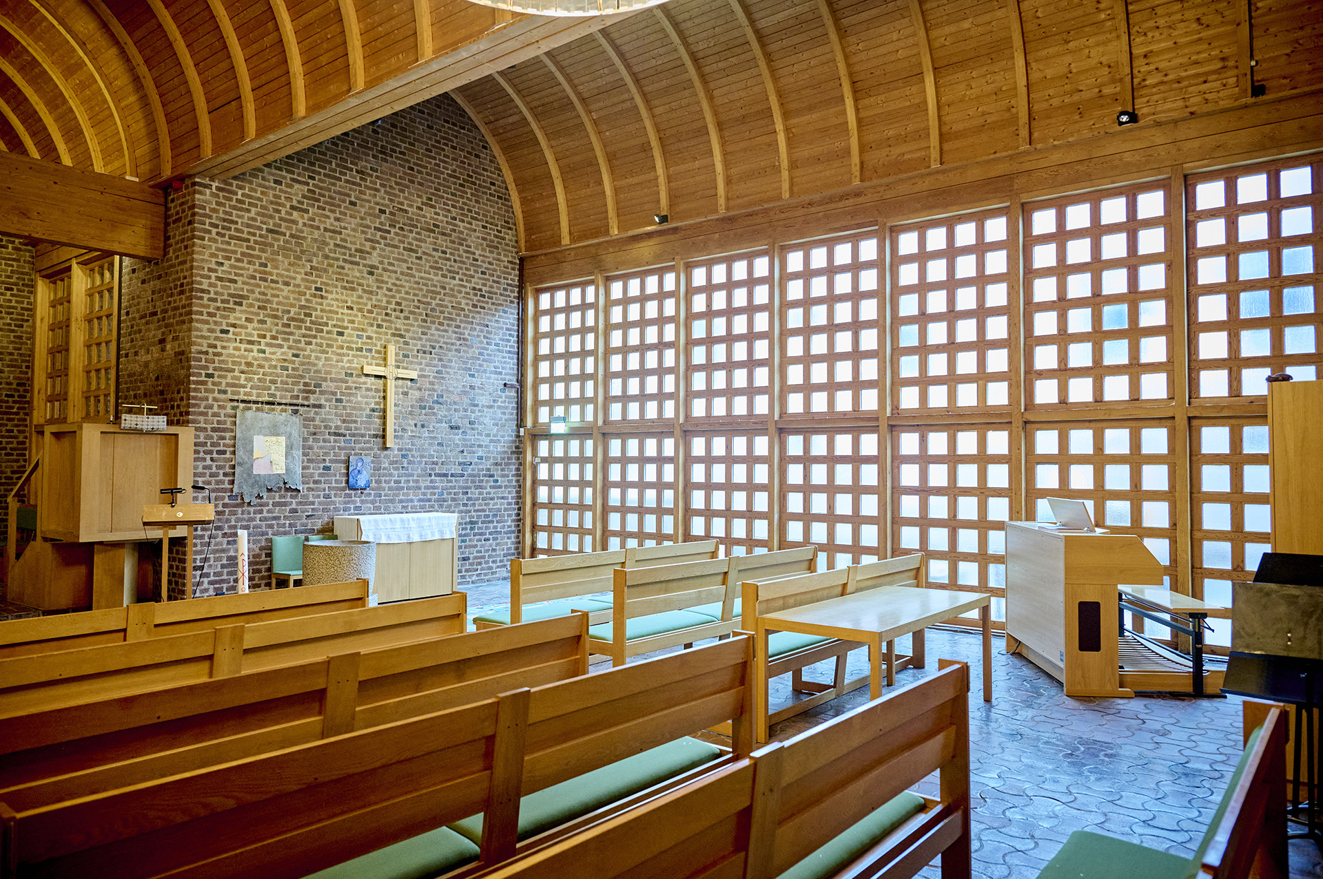 Interiör vu från Almtunakyrkan med fönstren och korset på vägen ii skimrande dagsljusbelysning.