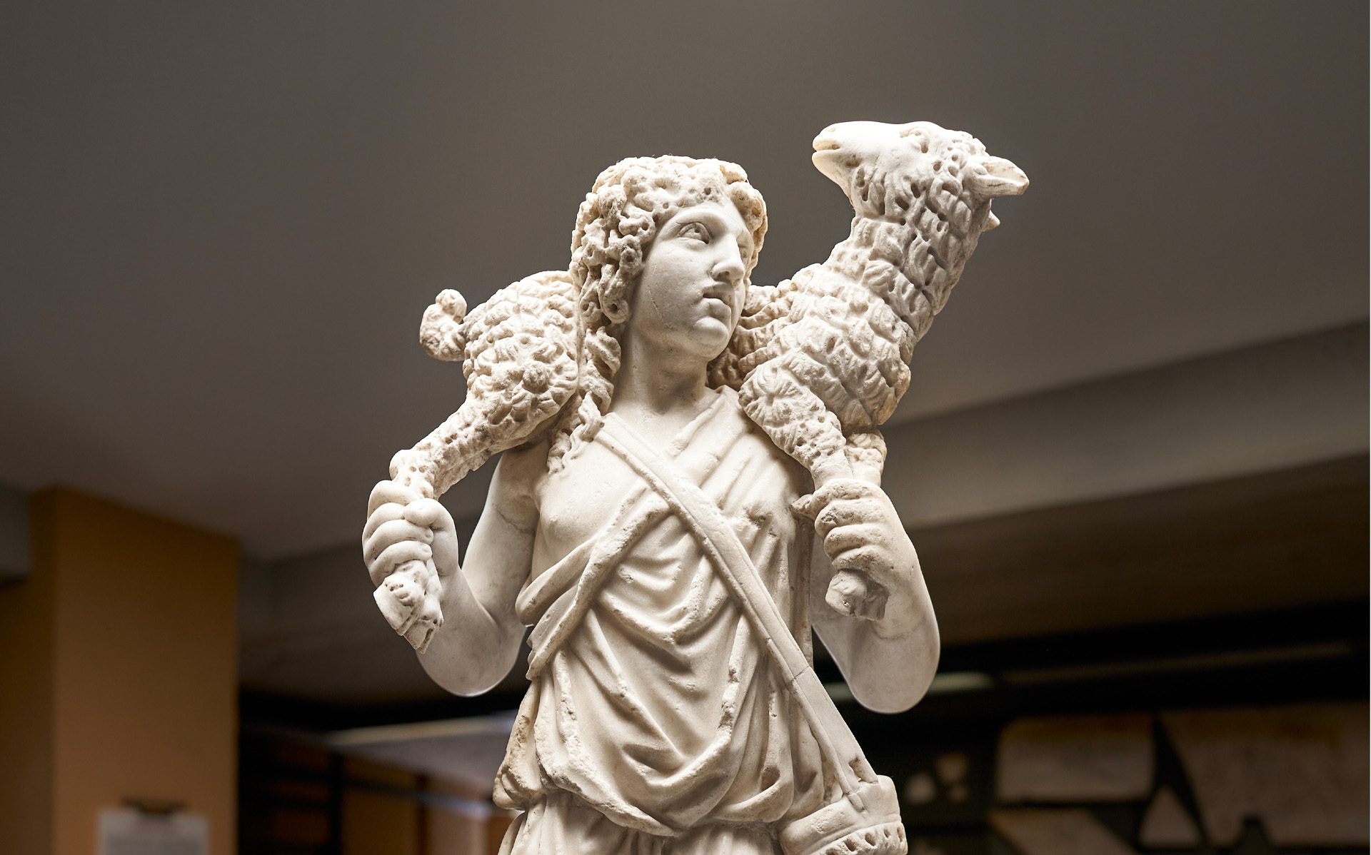 En vit staty föreställande en herde som bär ett får över axlarna.