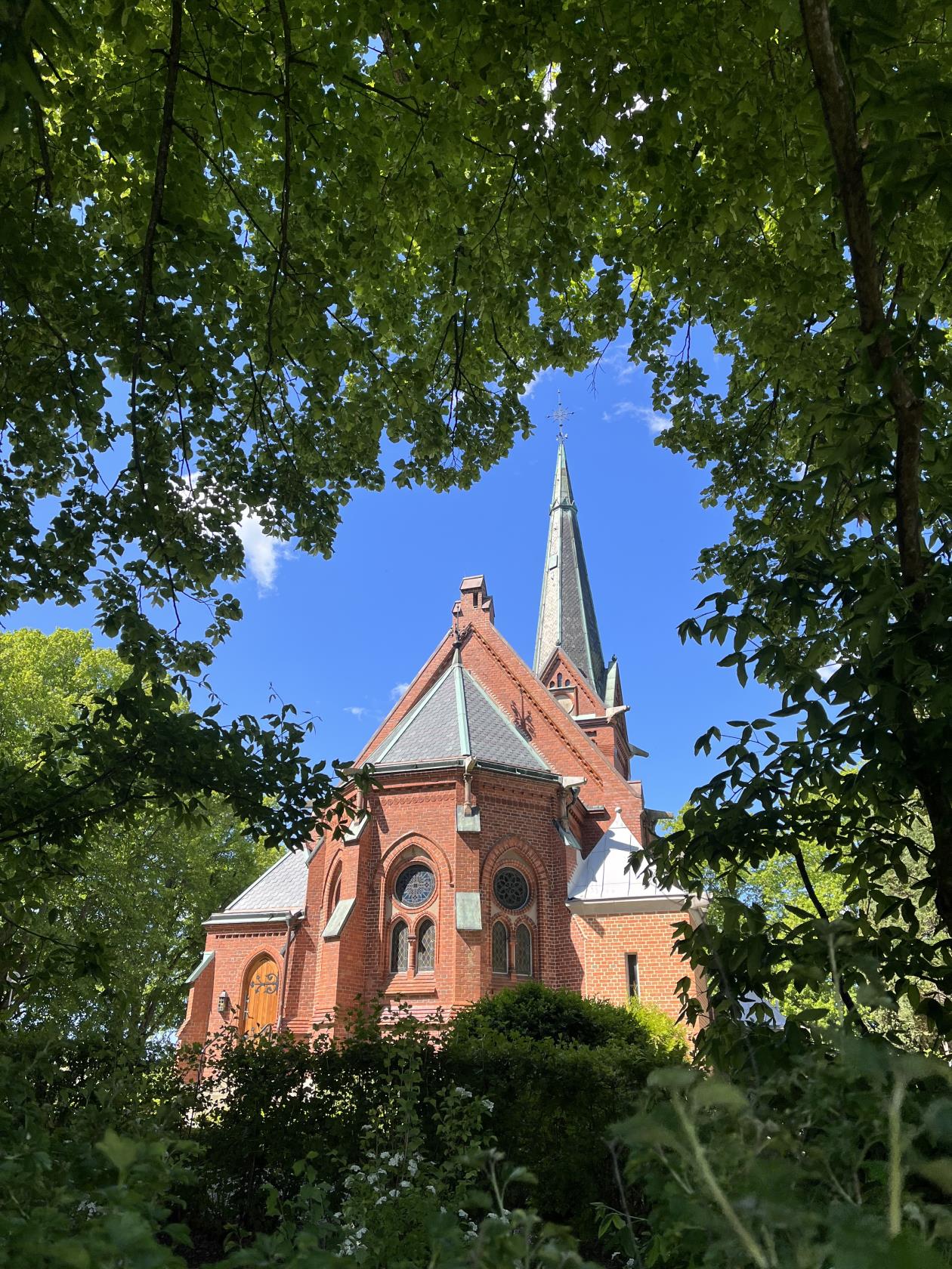 Norra Nöbbelövs kyrka exteriör med grönskande träd