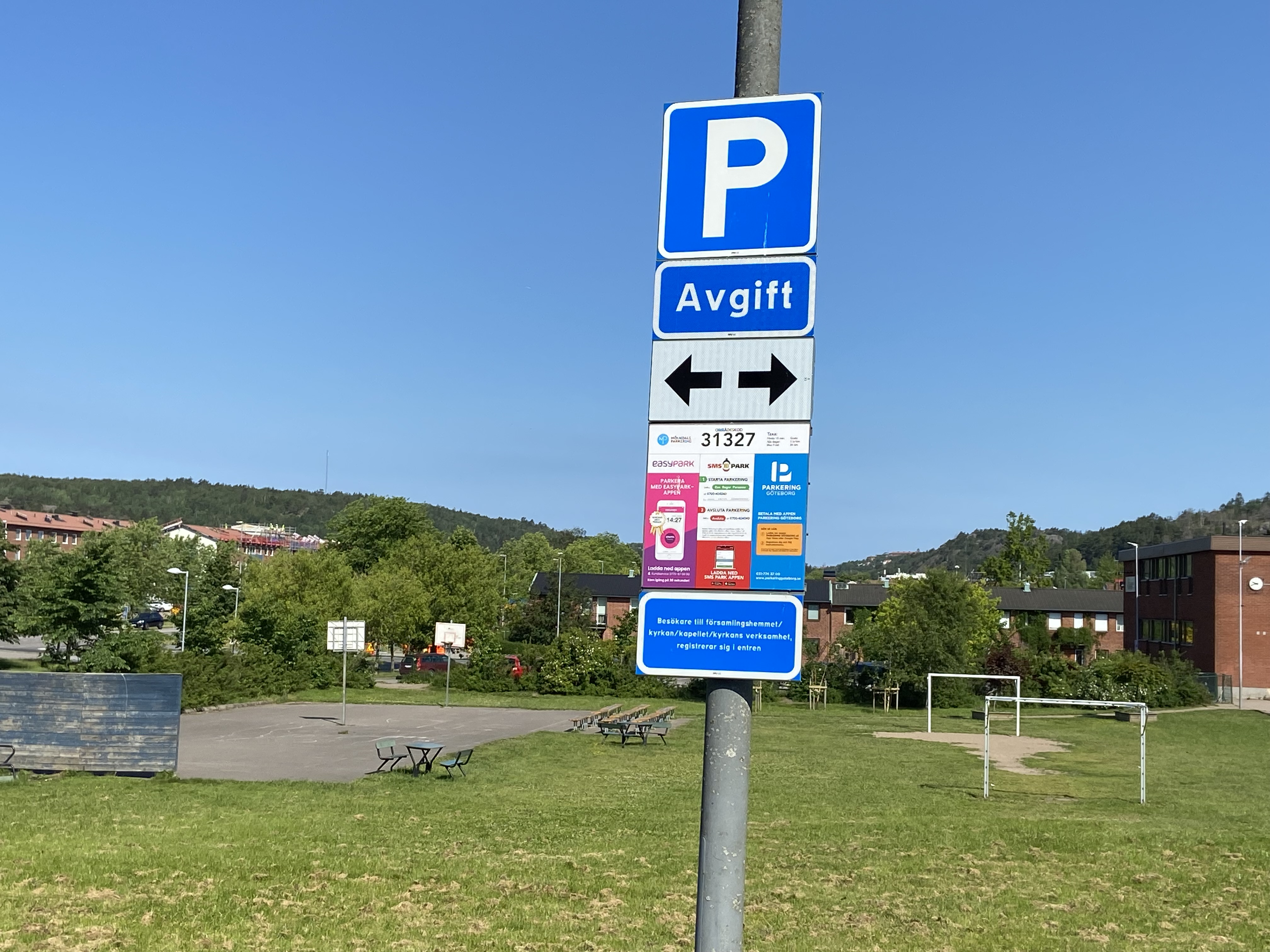 Skylt utanför Svenska kyrkans lokaler som berättar att det är en avgift att parkera. Men att det också är gratis om du är där på verksamhet. 