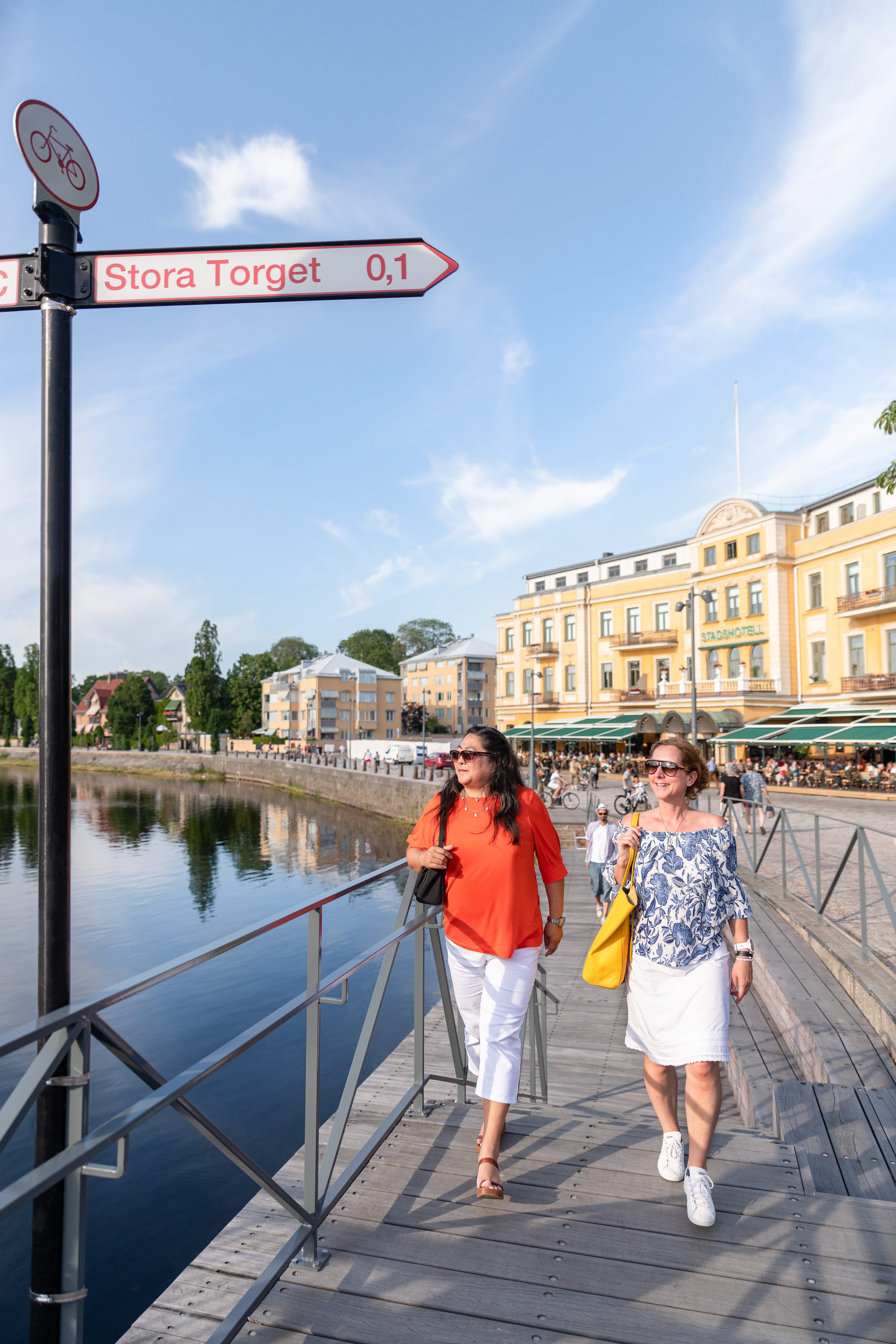 Kvinnor flanerar framför Stadshotellet i Karlstad.