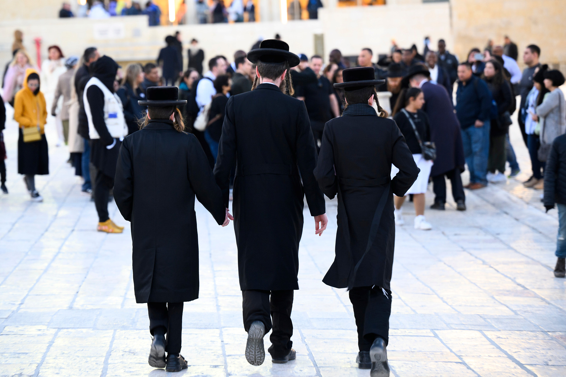 En man och två pojkar på väg till Klagomuren.