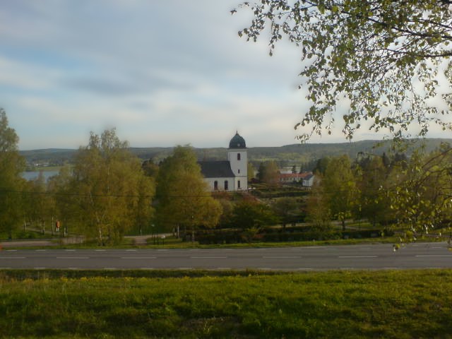 Tuna kyrka, vårbild med grönskande träd.