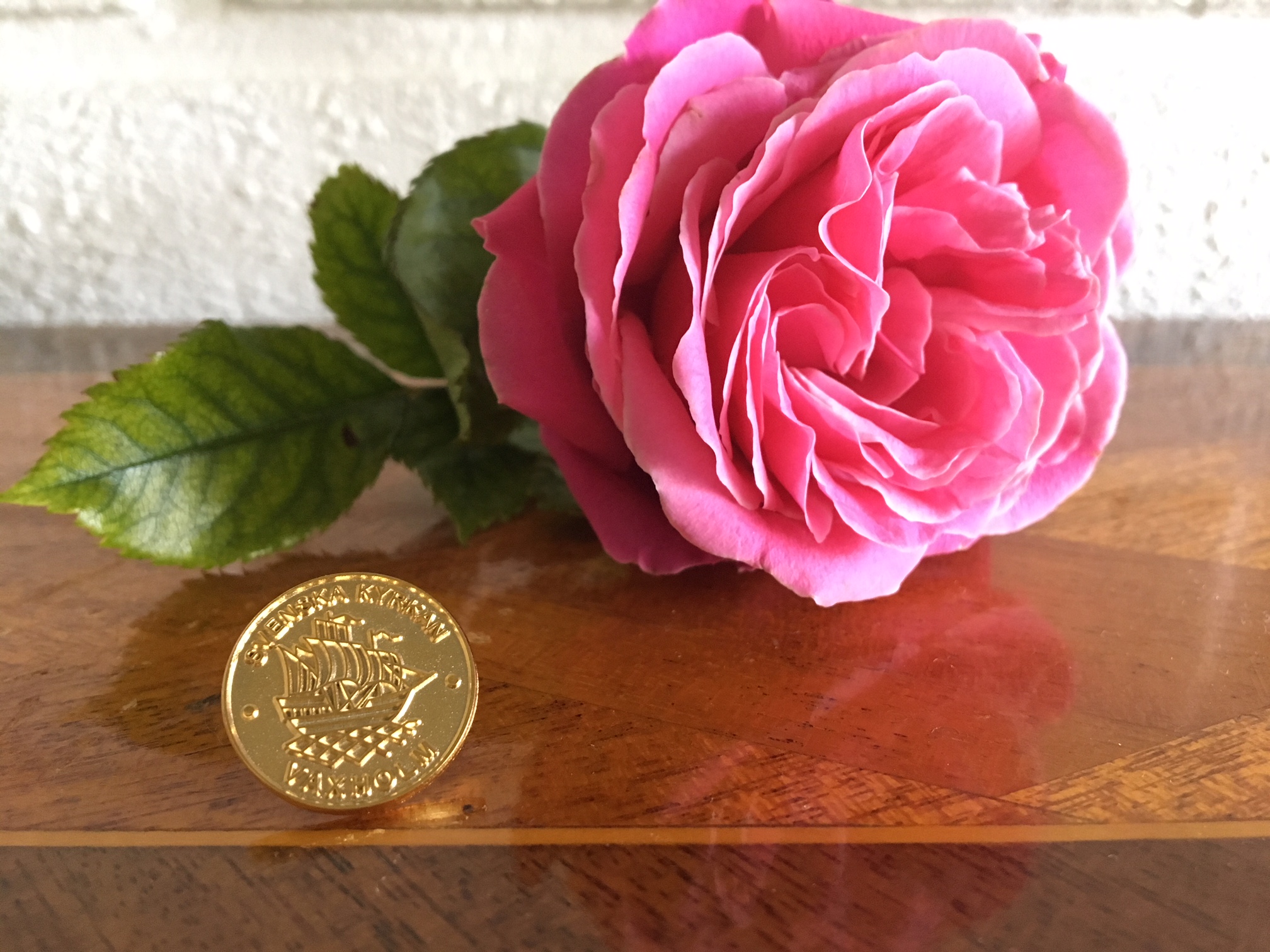 Guldpin med text och en rosa ros.