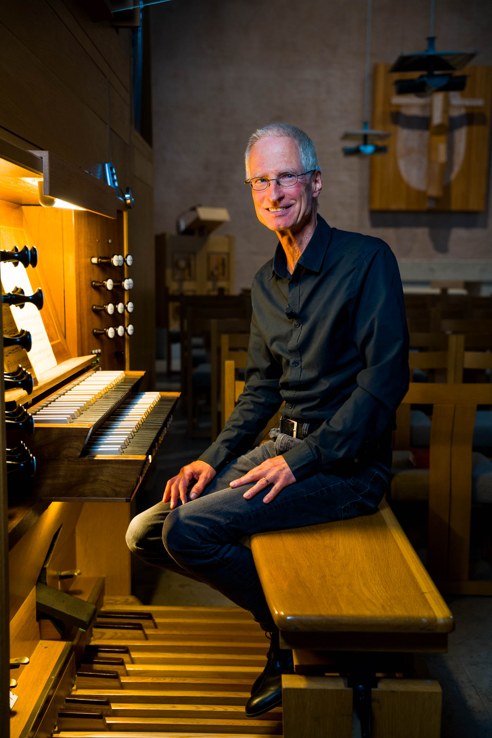 Foto på Martin Schiffer, organist, sittande vid orgeln i Hornsbergskyrkan.