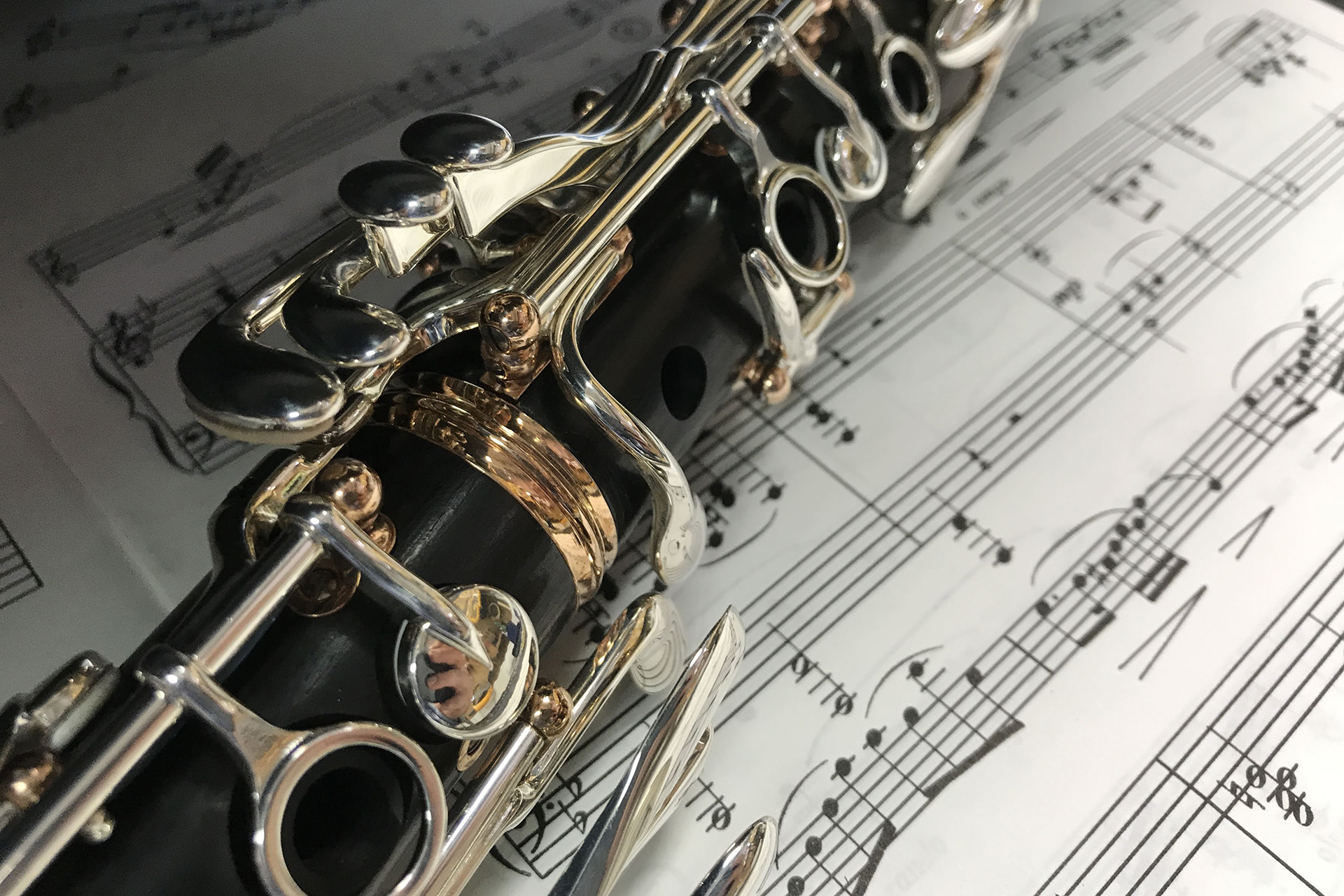 Närbild på en klarinett som ligger på att notblad.
