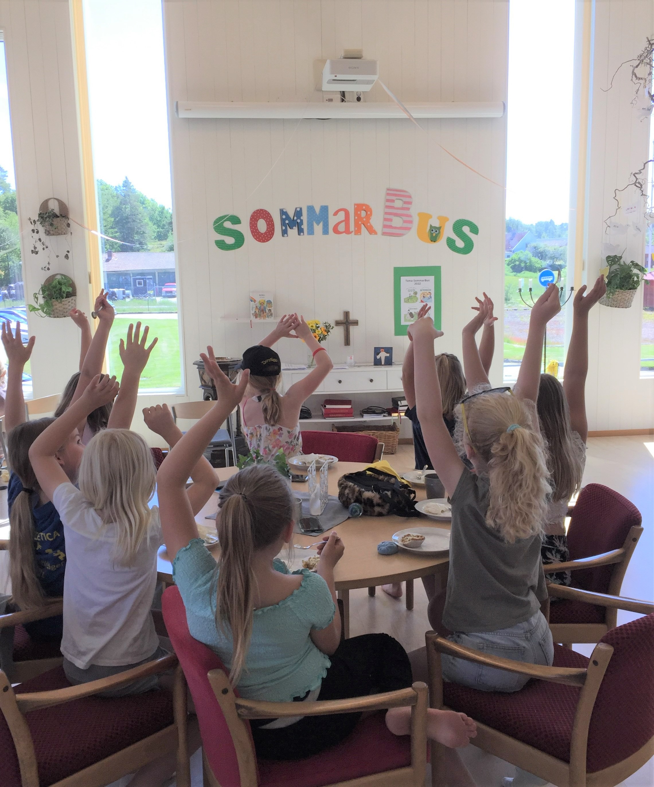 Ett tiotal barn räcker upp händerna 