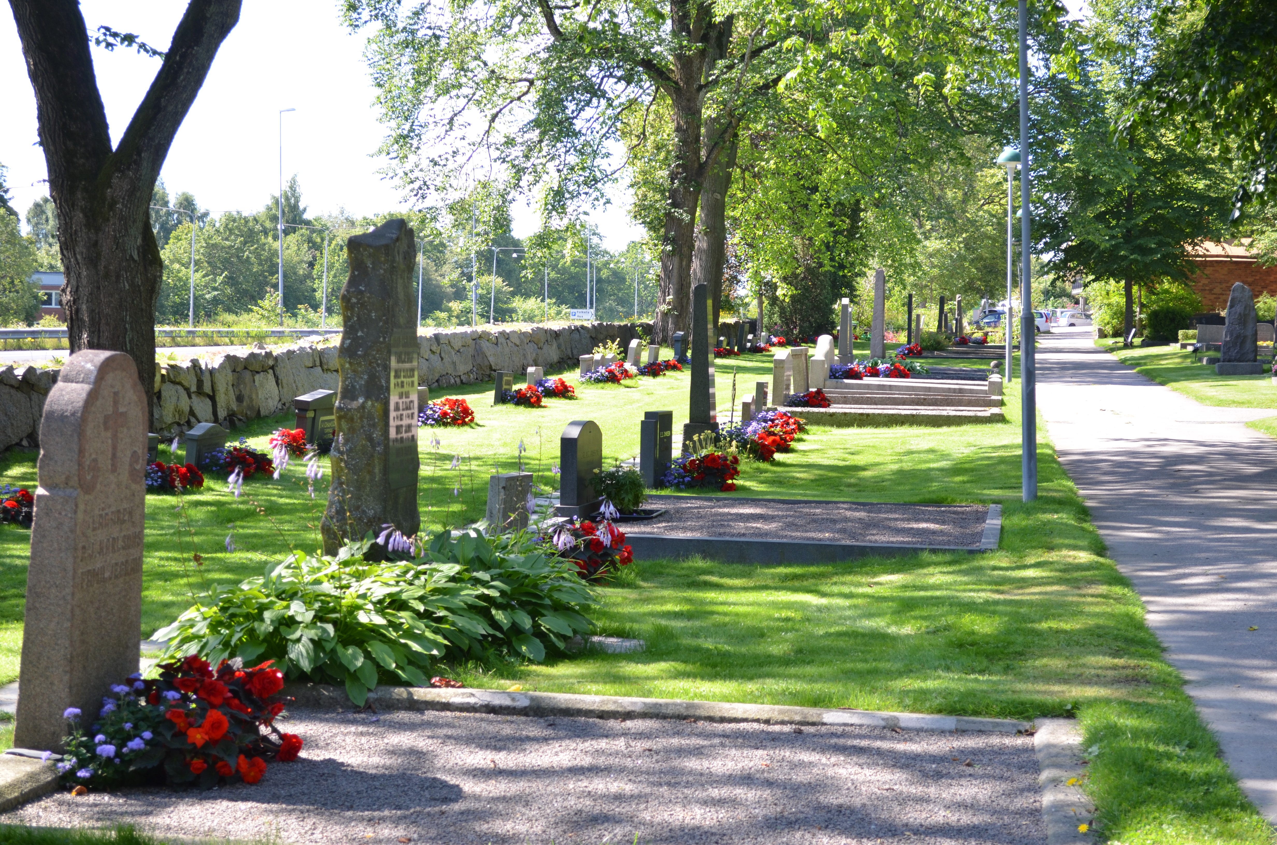 Gamla kyrkogården med gravstenar längs kyrkogårdsmuren