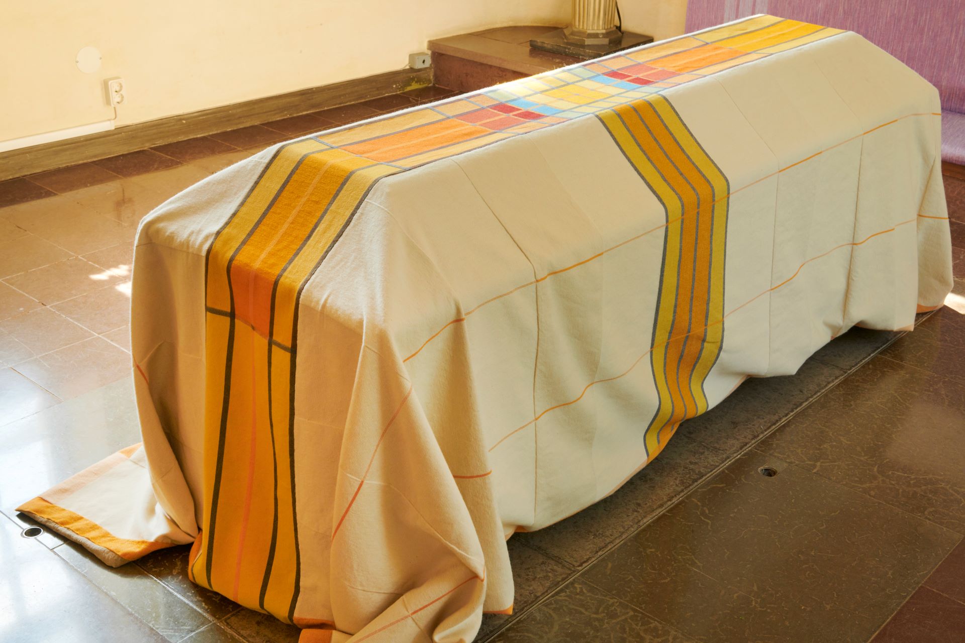 Gult bårtäcke över kista. 