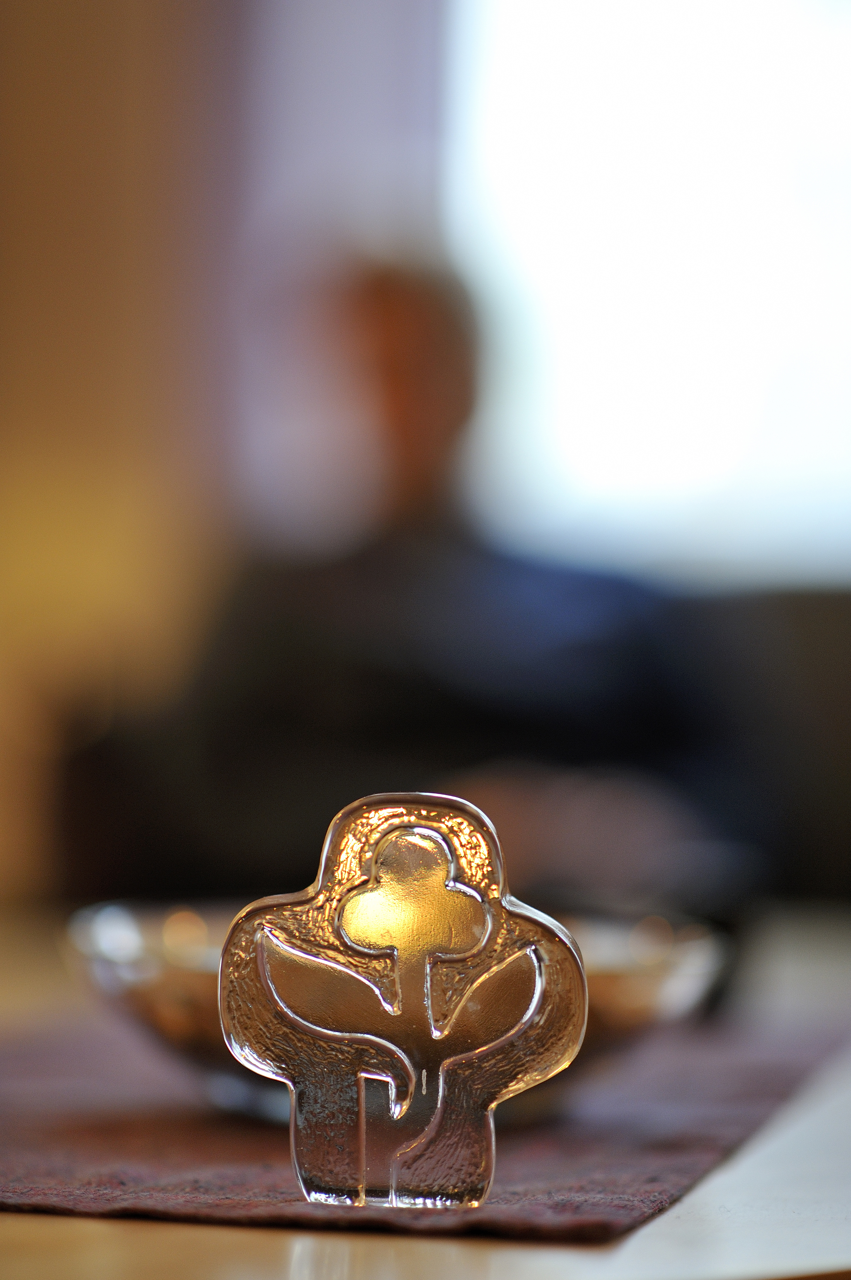 Ett kors med en blomma i, som växer ut från en avbruten stam.