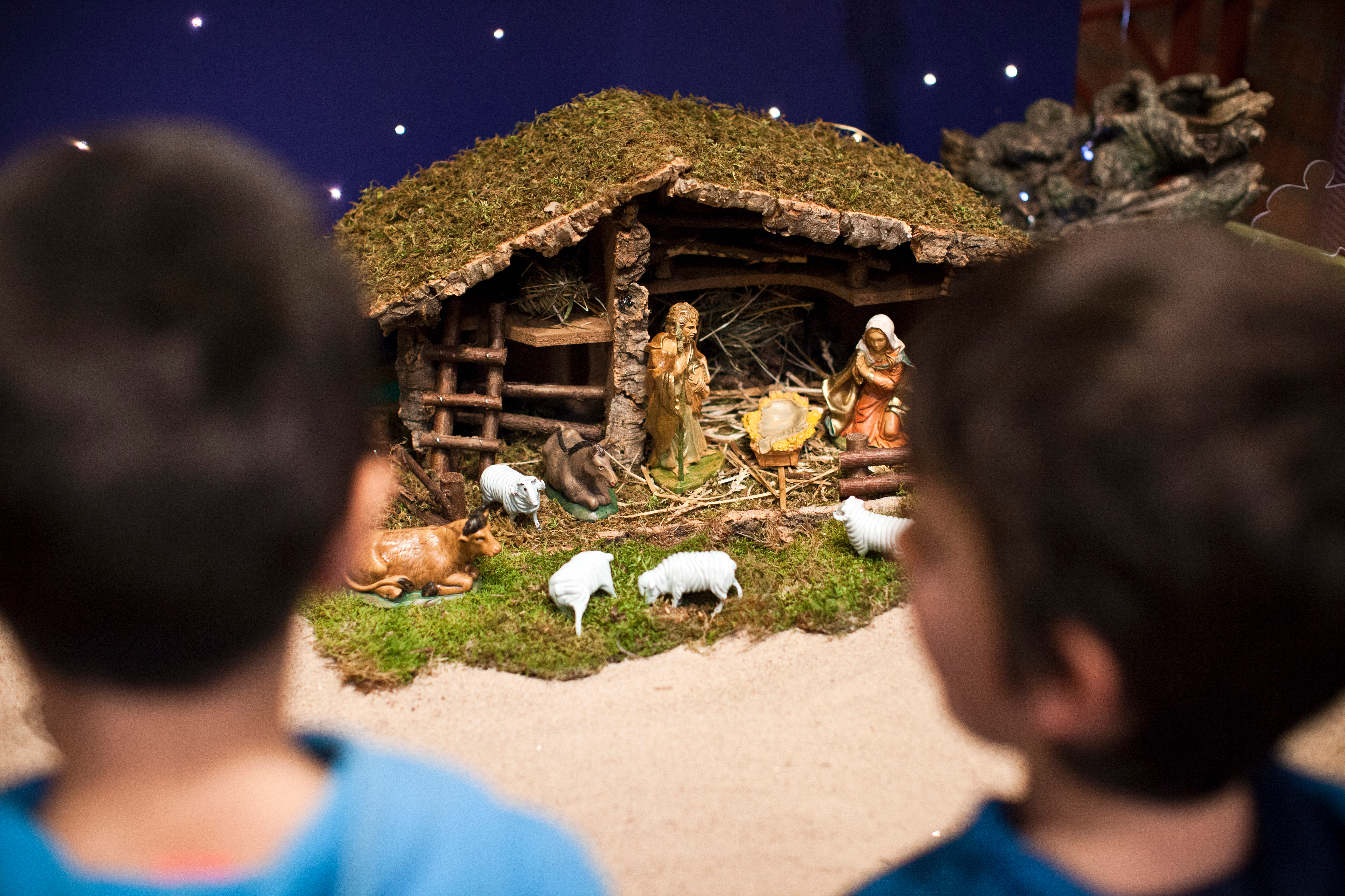 Två små pojkar står vid en julkrubba.