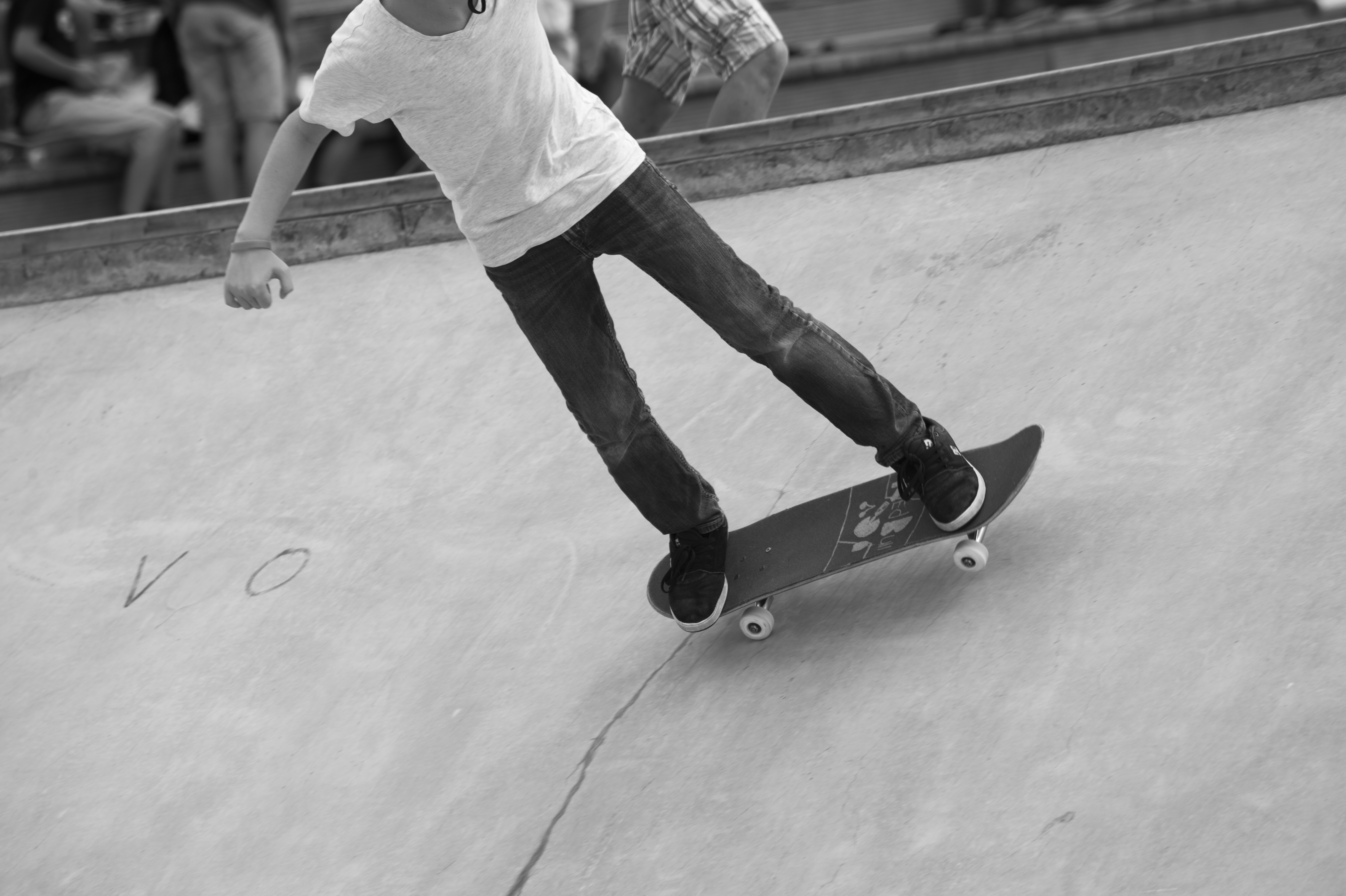 Svartvit bild på ett barn som åker skateboard.