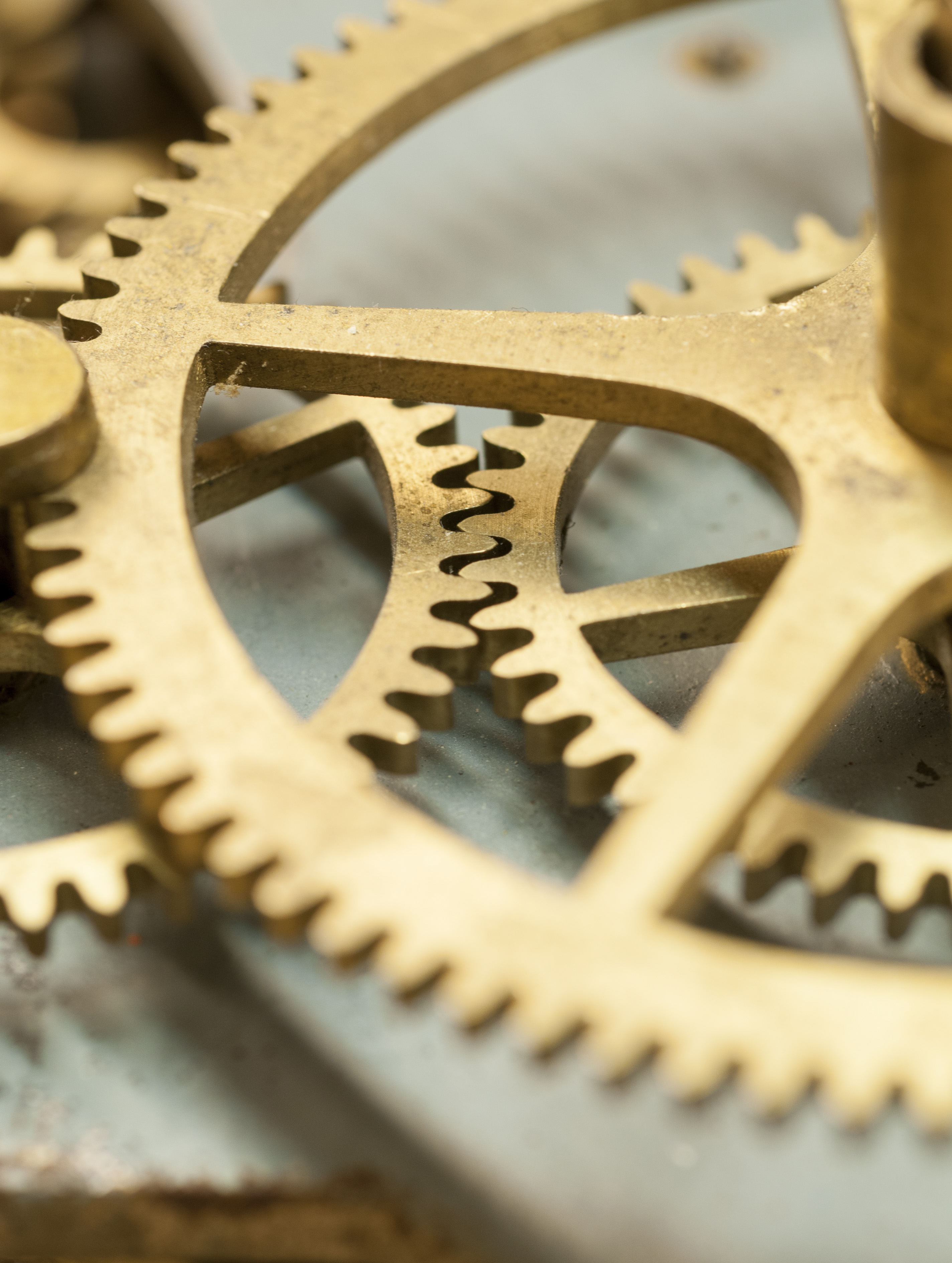 Närbild på guldfärgade kugghjul i ett urverk.