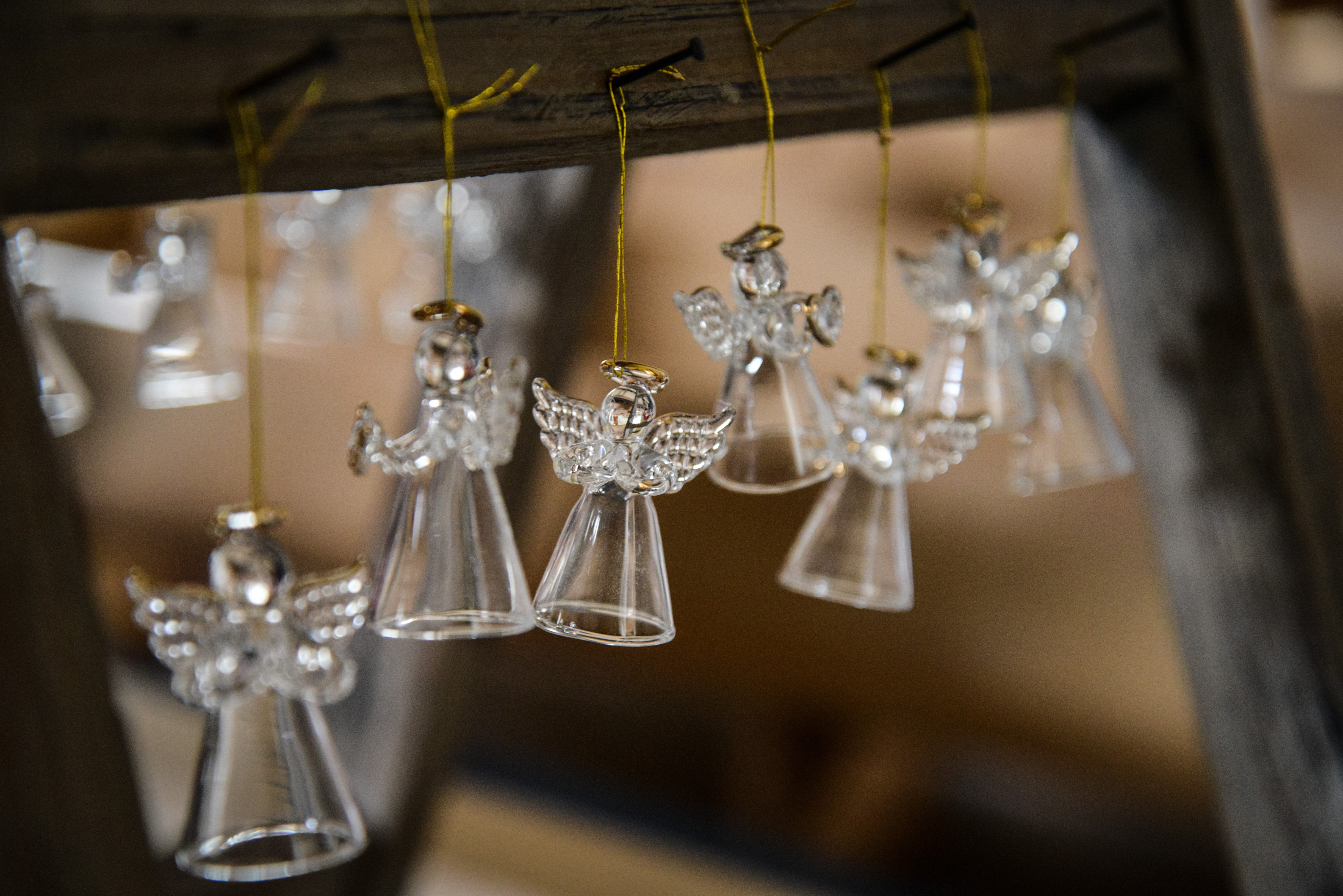 Flera små glasänglar upphängda på spikar.