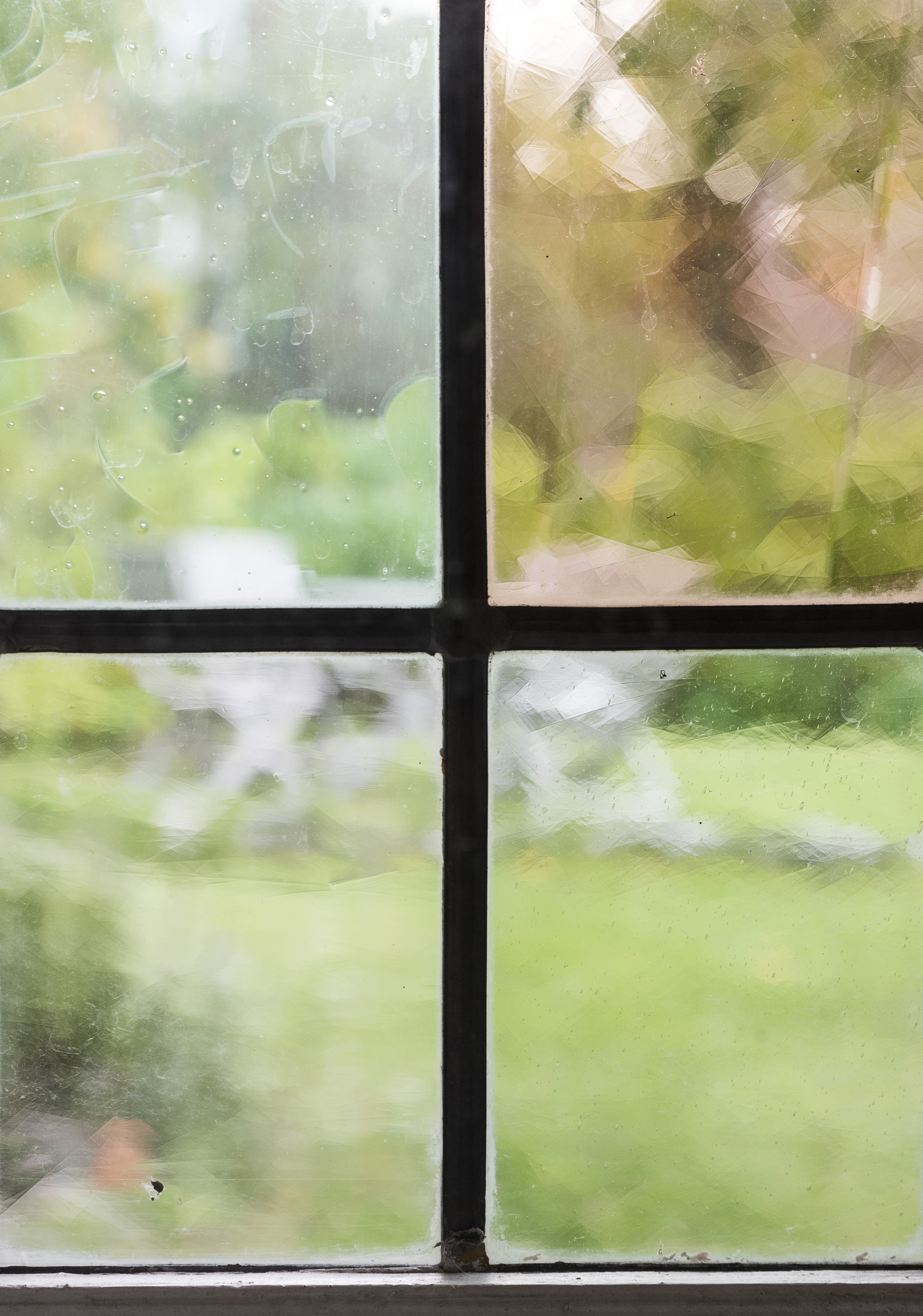 Trädgårdsmöbler syns utomhus genom ett suddigt fönster.