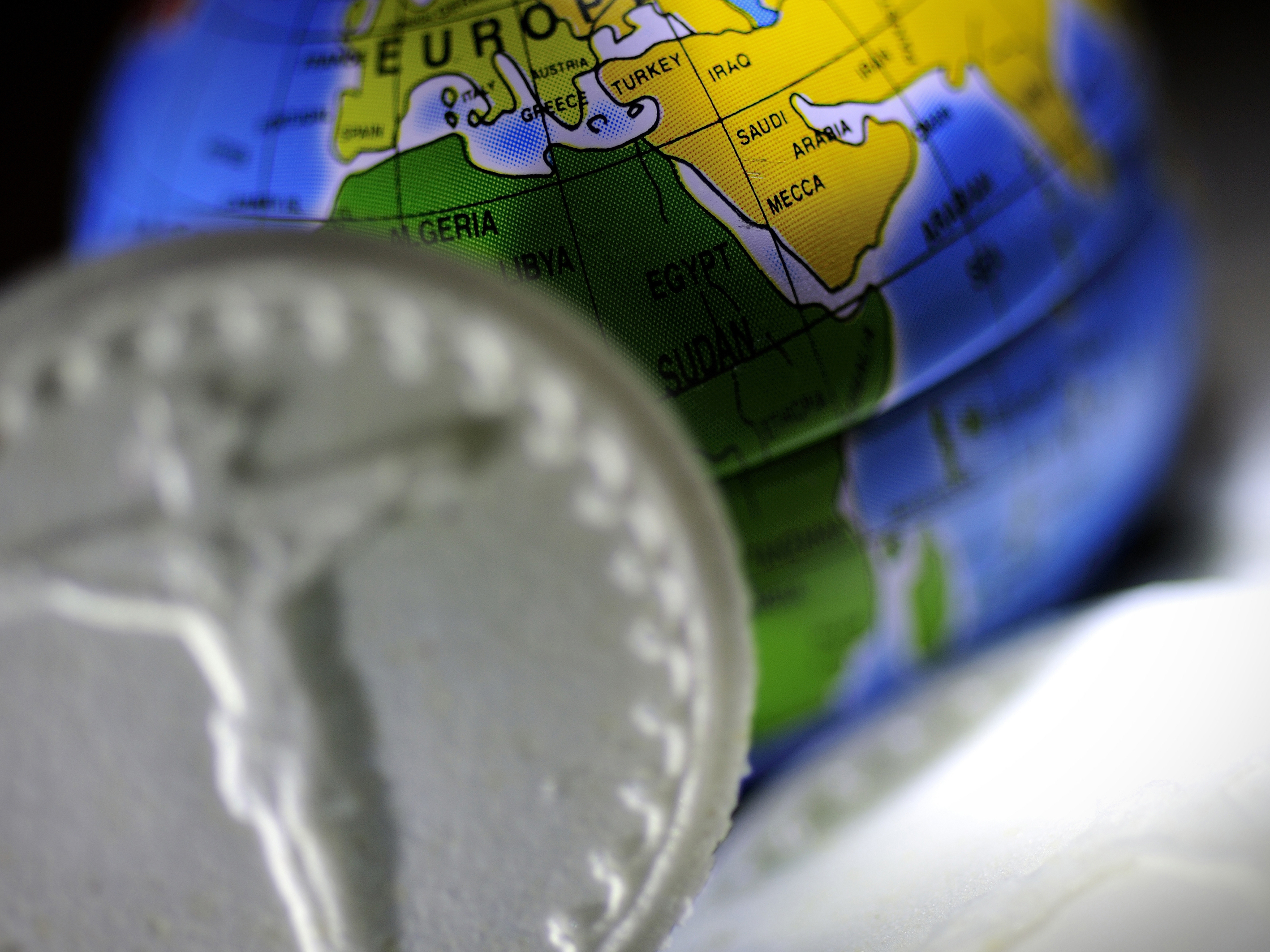 Närbild på en oblat och en liten jordglob.