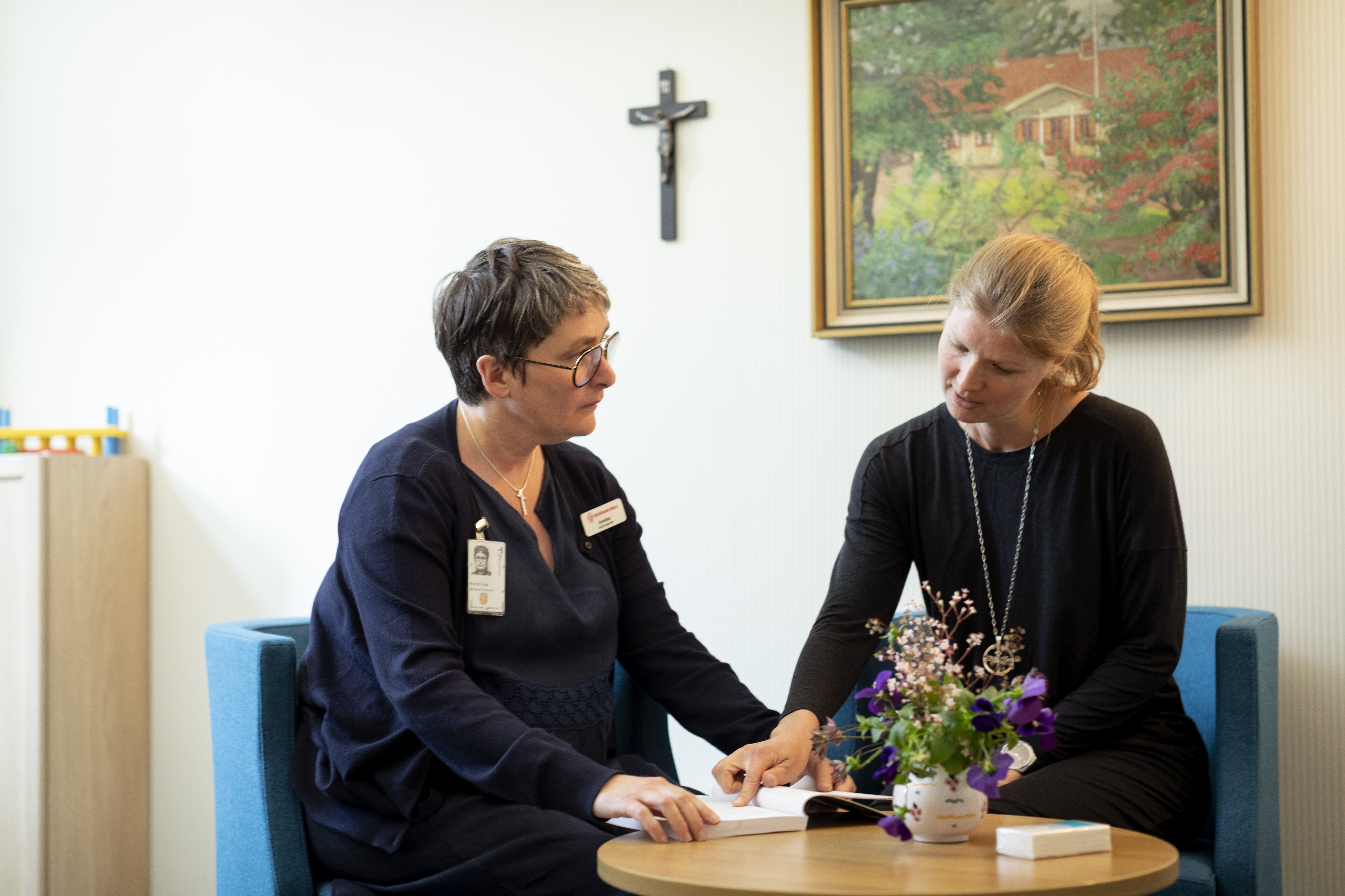 Två kvinnor sitter och samtalar runt ett litet bord.