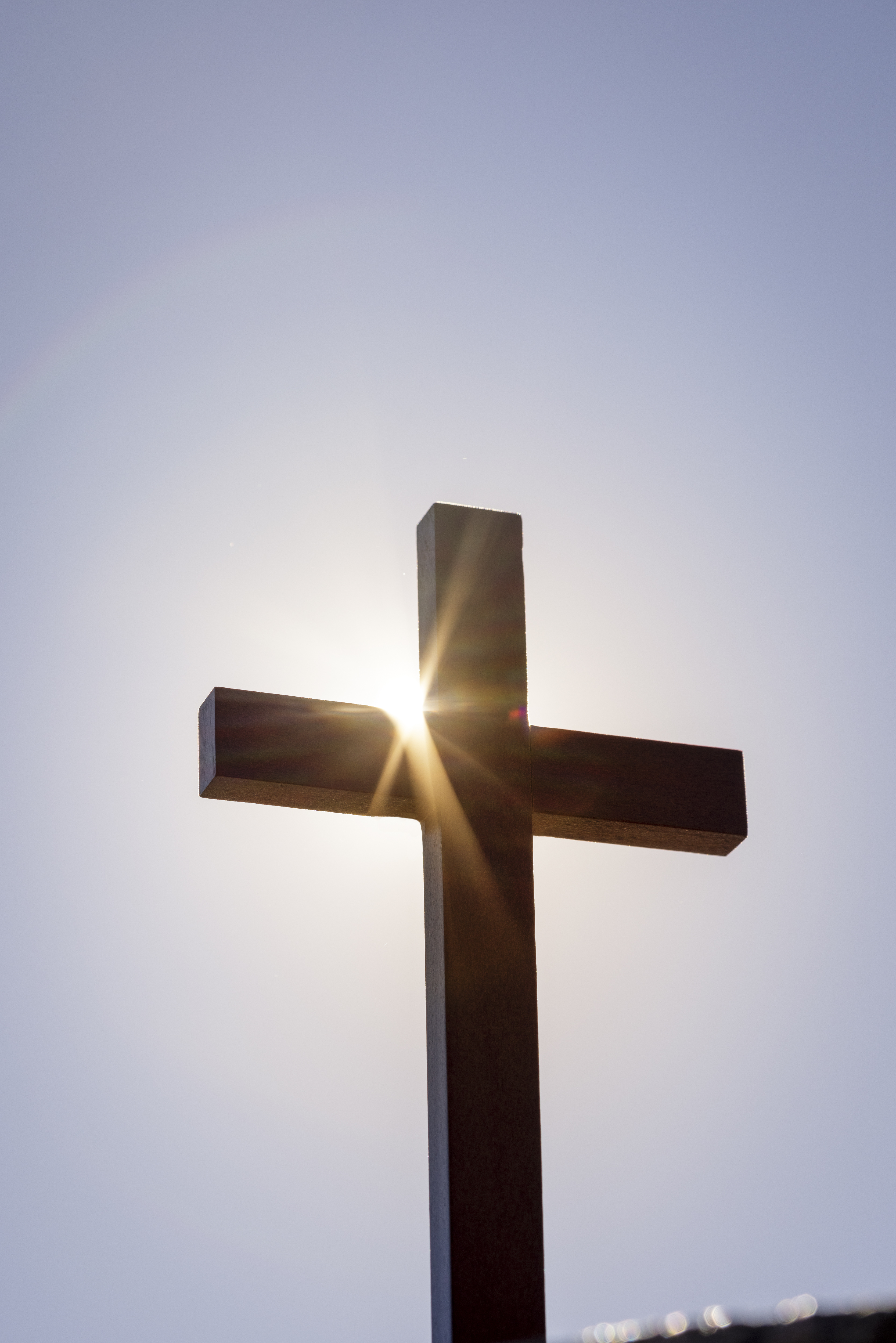 Ett enkelt kors i motljus.