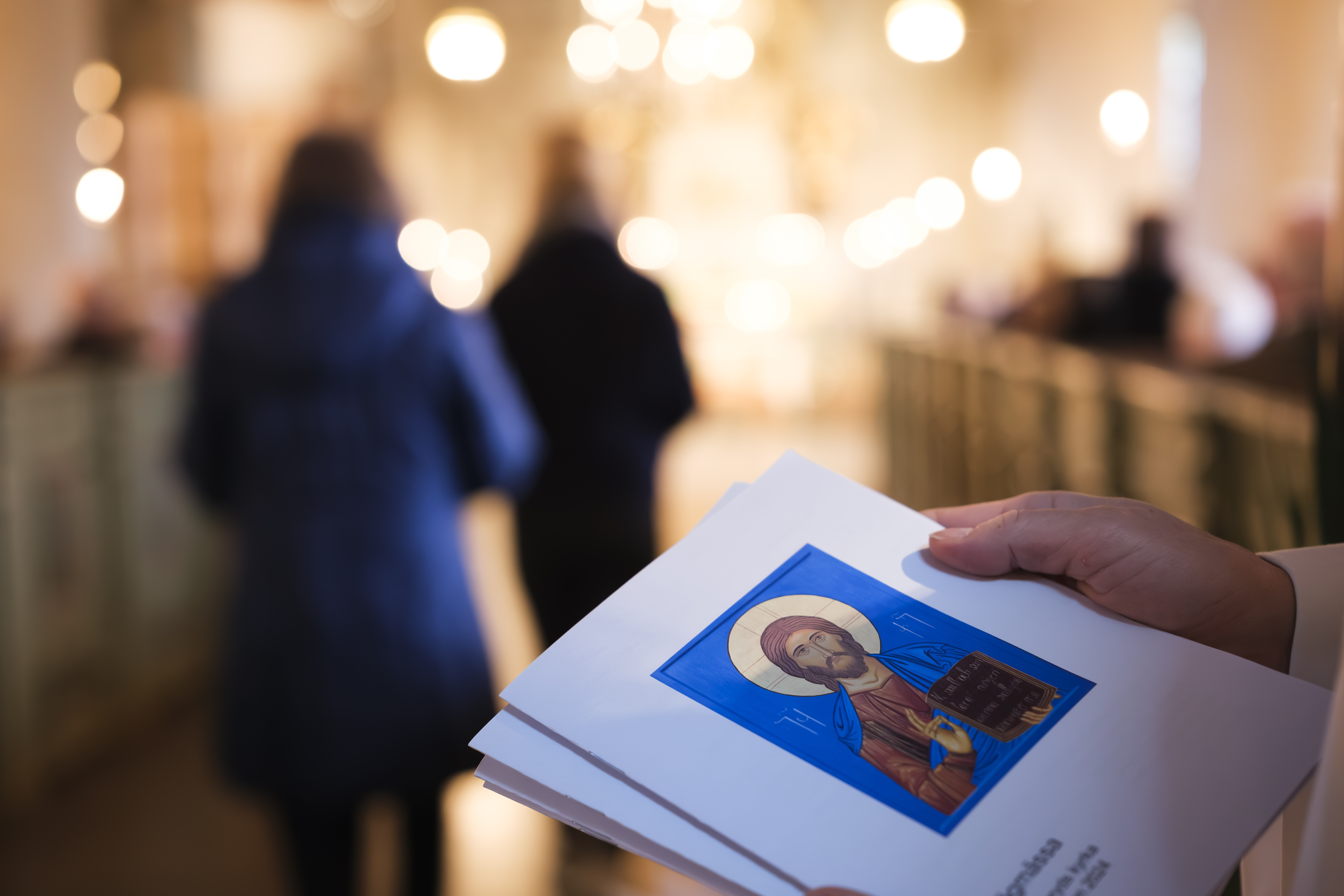 Närbild på händer som delar ut agendor. 